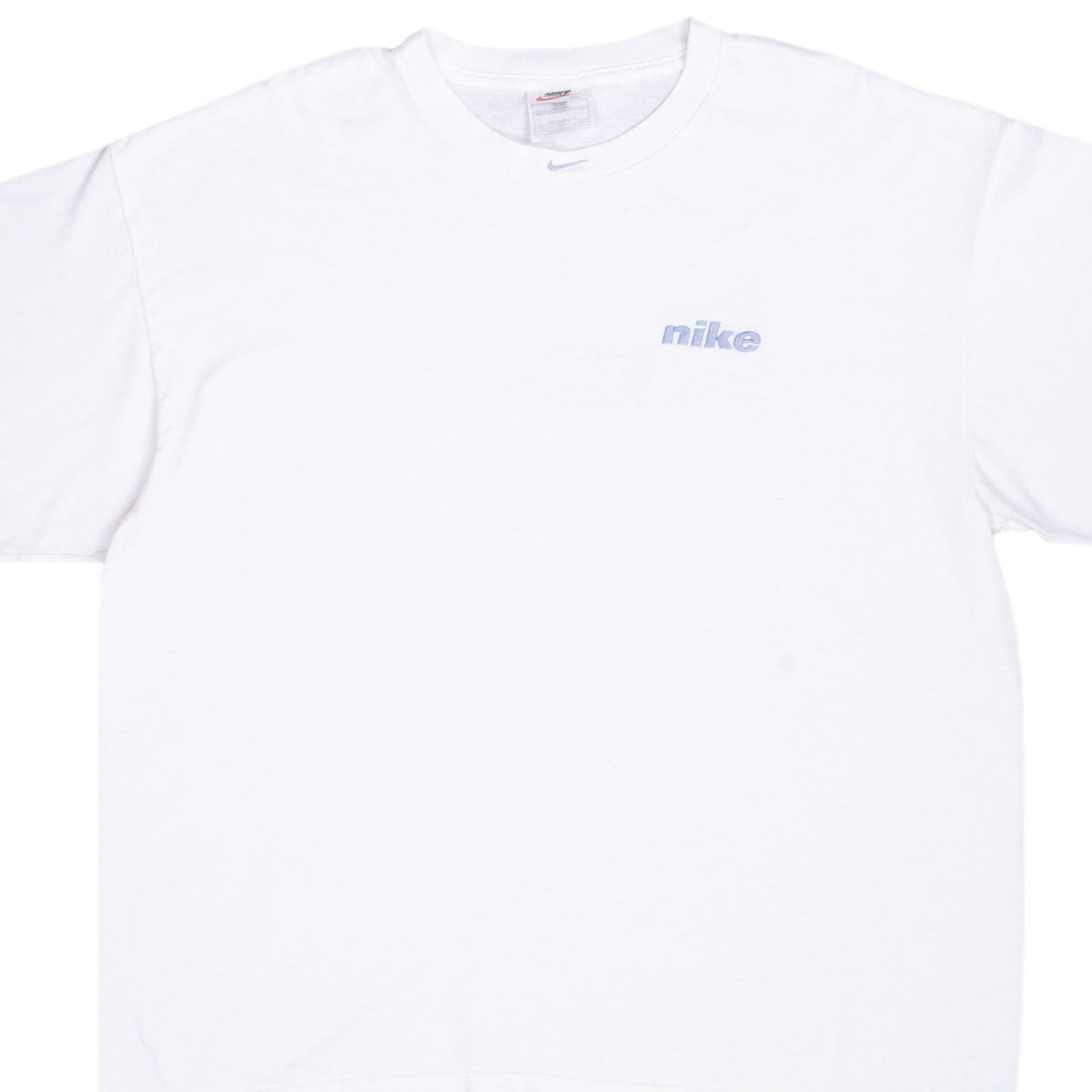 Front chest of white Nike T-shirt with light blue embroidered wordmark and neckline Swoosh