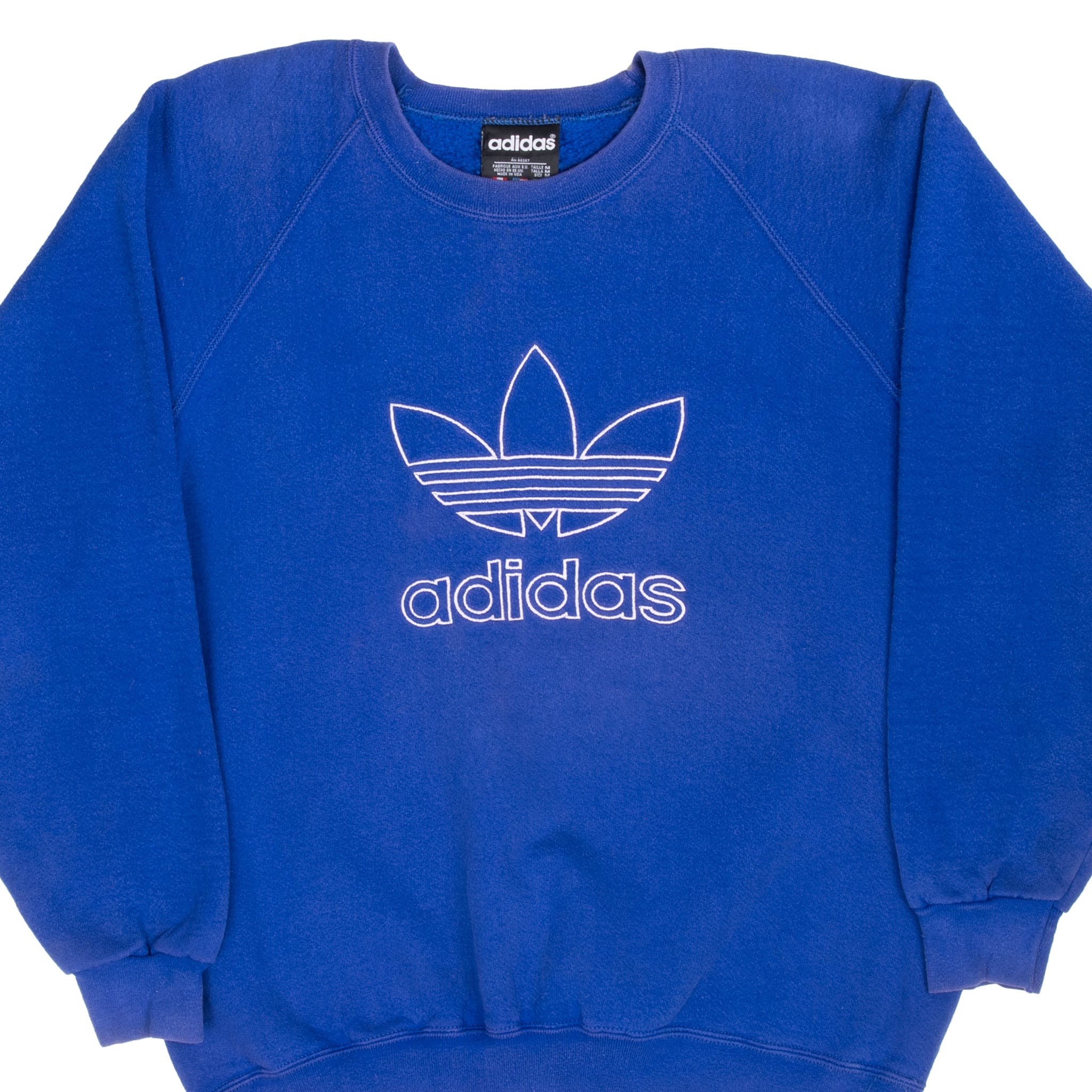 Front close-up of blue Adidas crewneck with outlined Trefoil logo and raglan sleeves