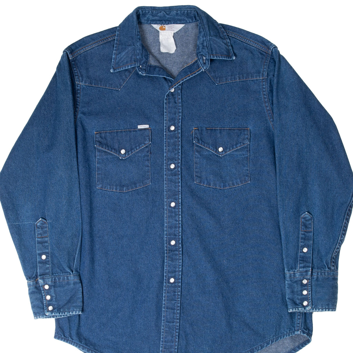 Front of blue Carhartt denim shirt with pearl snaps and two flap chest pockets
