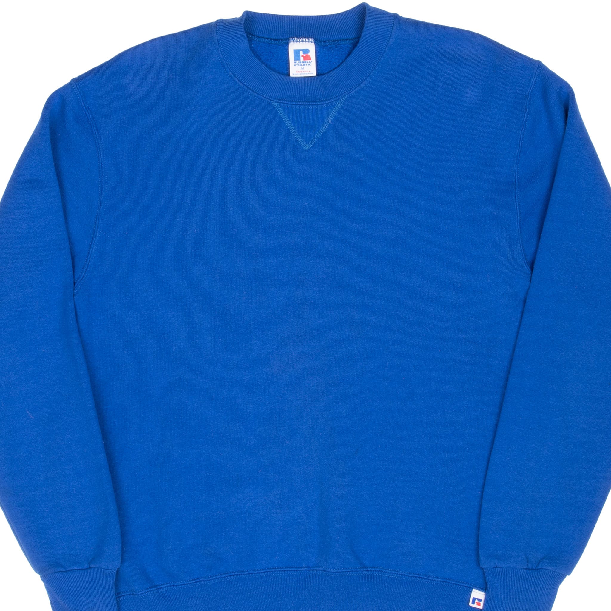 Front detail of blue Russell crewneck sweatshirt with V-stitch collar and logo tab at hem