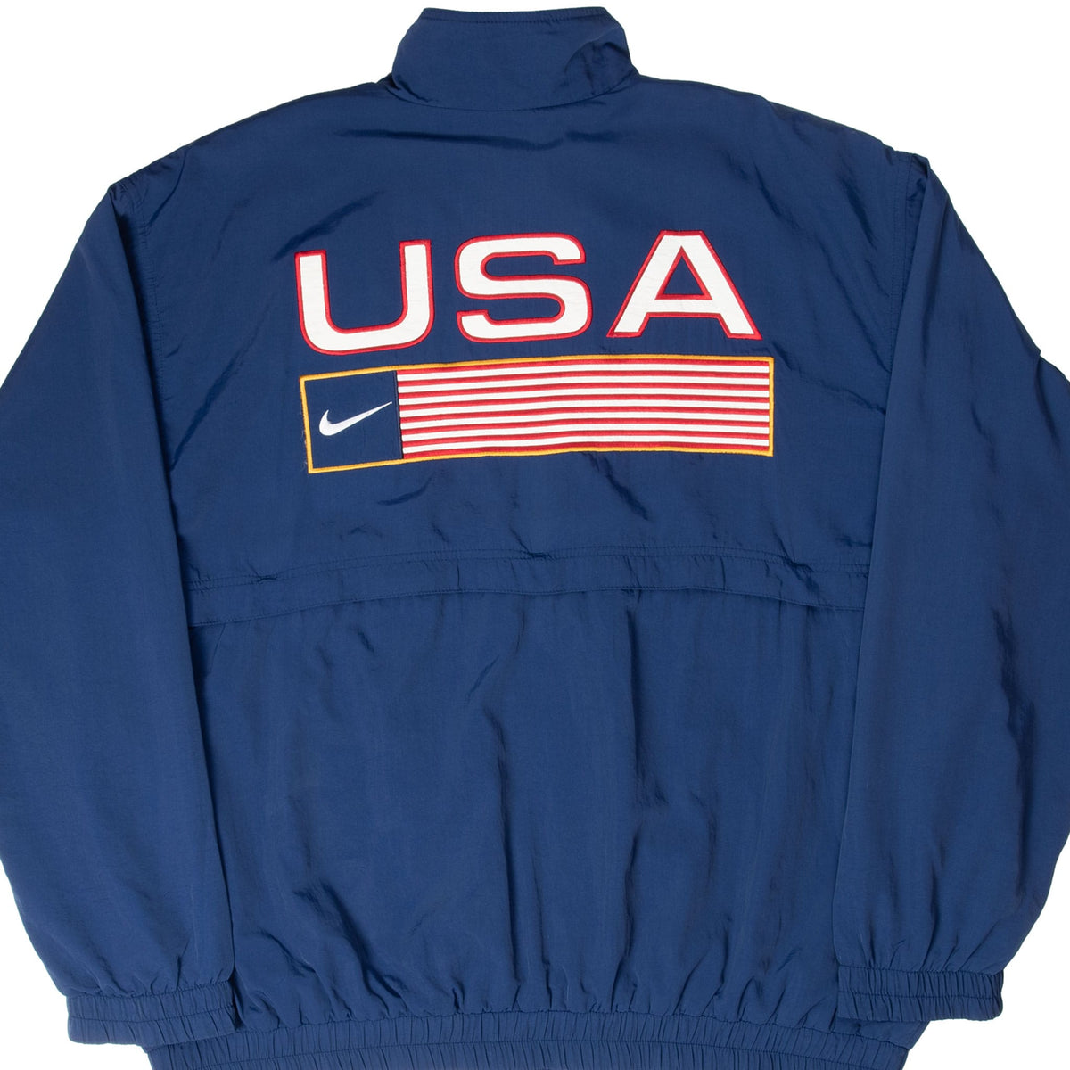 Back of navy Nike Team USA windbreaker with large USA lettering and striped Swoosh flag graphic