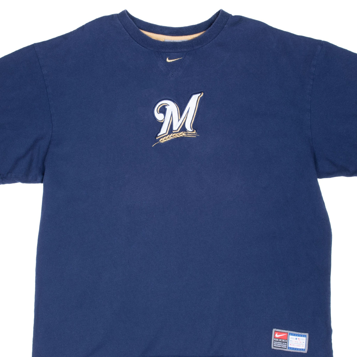 Front detail of blue Nike Milwaukee Brewers T-shirt with M logo, gold Swoosh and hem patch
