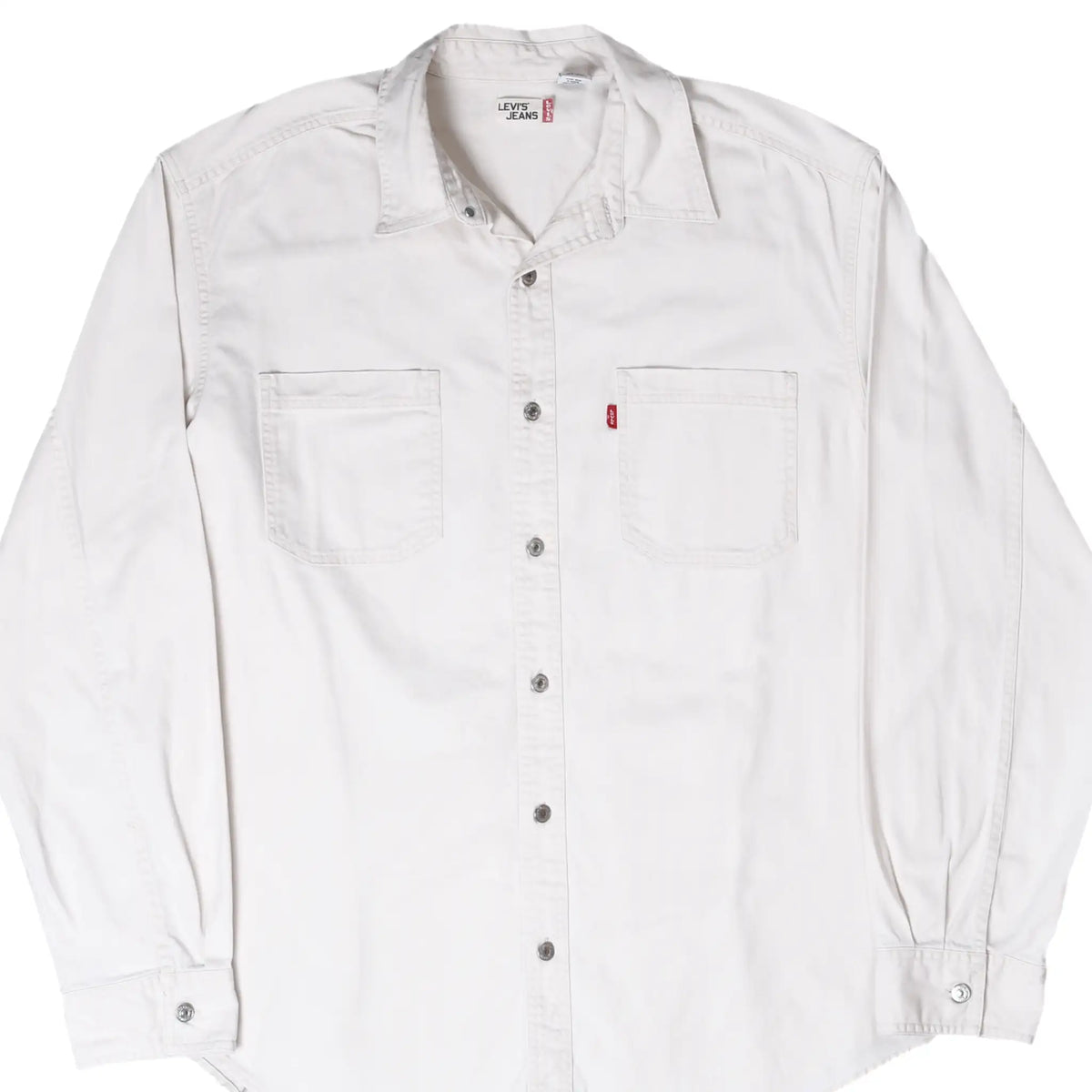 Front of white Levi's denim shirt with long sleeves, snap buttons, two chest pockets, and red tab
