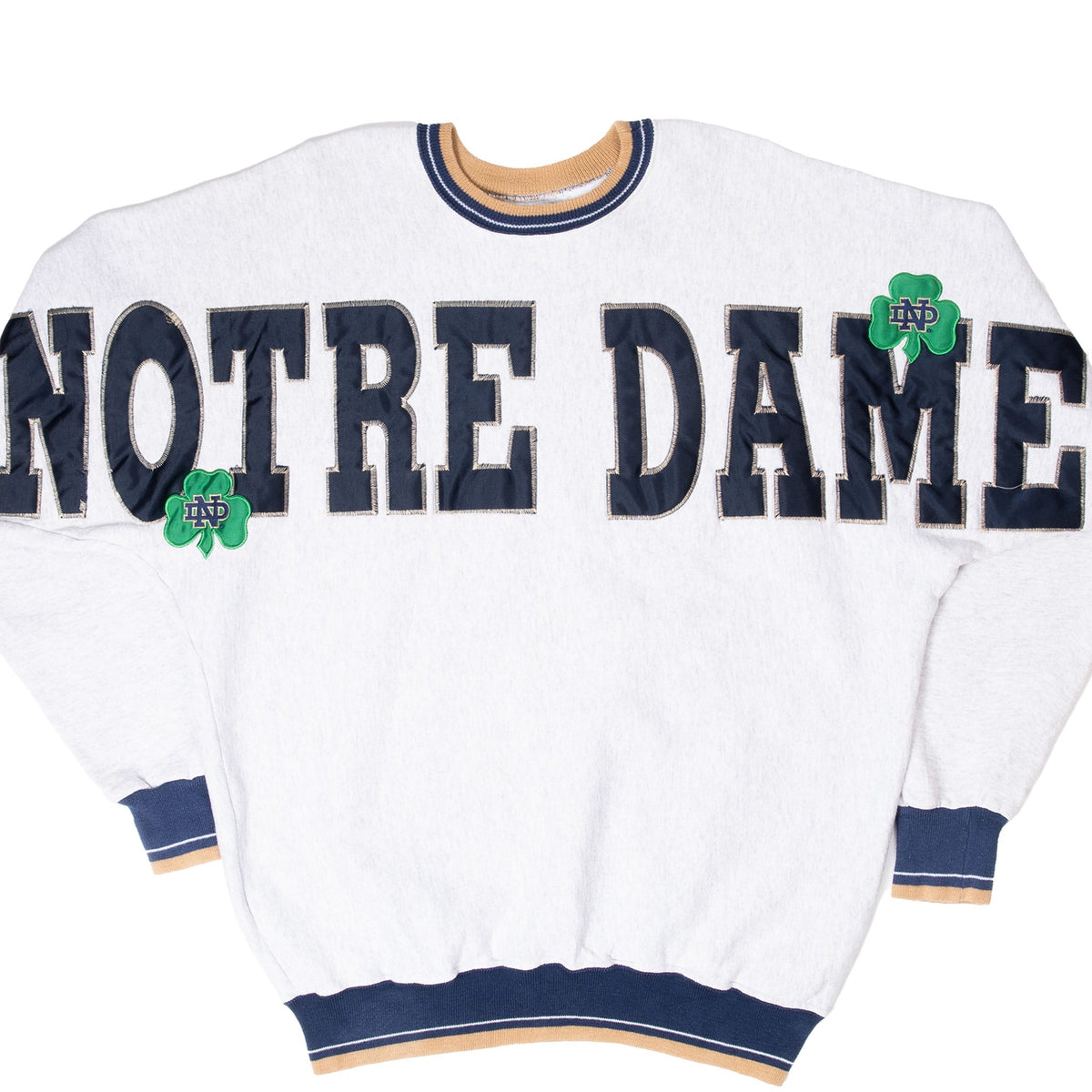 Front of light gray Notre Dame sweatshirt with navy appliqué lettering and green shamrocks
