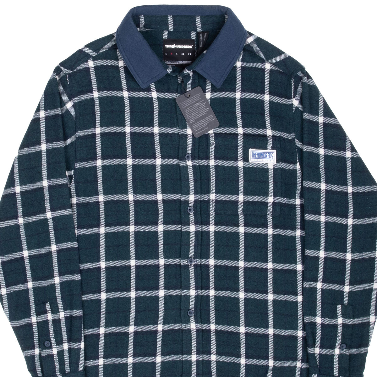 Front detail of The Hundreds green plaid flannel shirt with contrast collar, chest patch, and hangtag