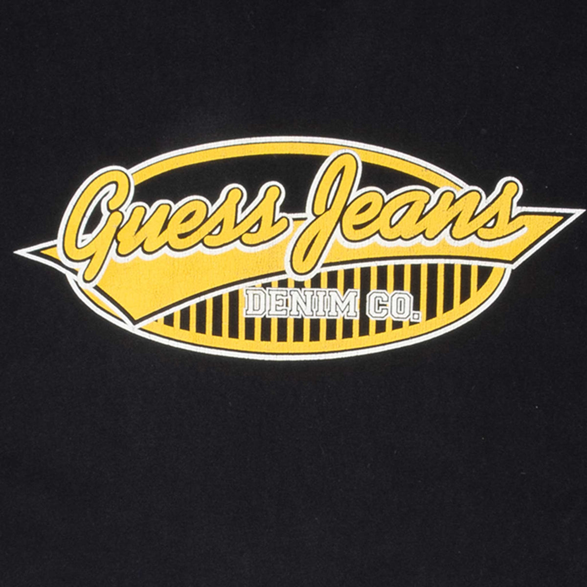 Close-up of yellow and white Guess Jeans Denim Co. chest graphic on black fabric