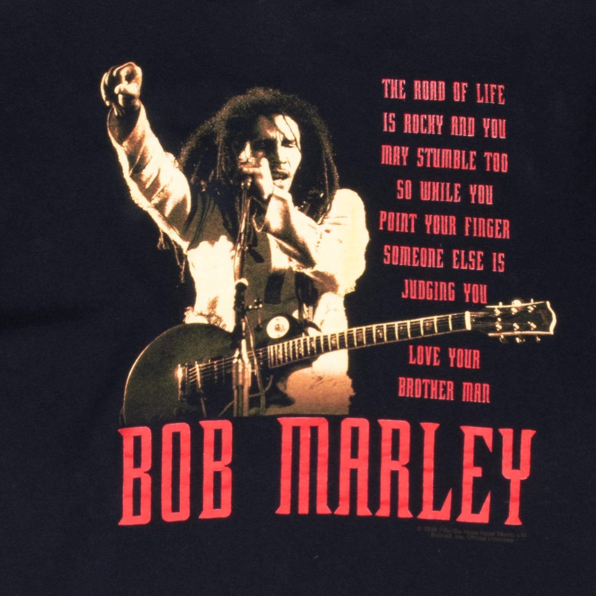 Close-up of back print showing Bob Marley with guitar, red quote and name lettering
