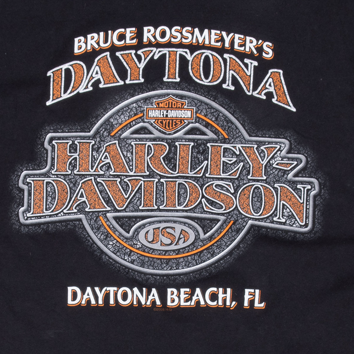 Close-up of Bruce Rossmeyer's Daytona Harley-Davidson back graphic in orange, white and gray