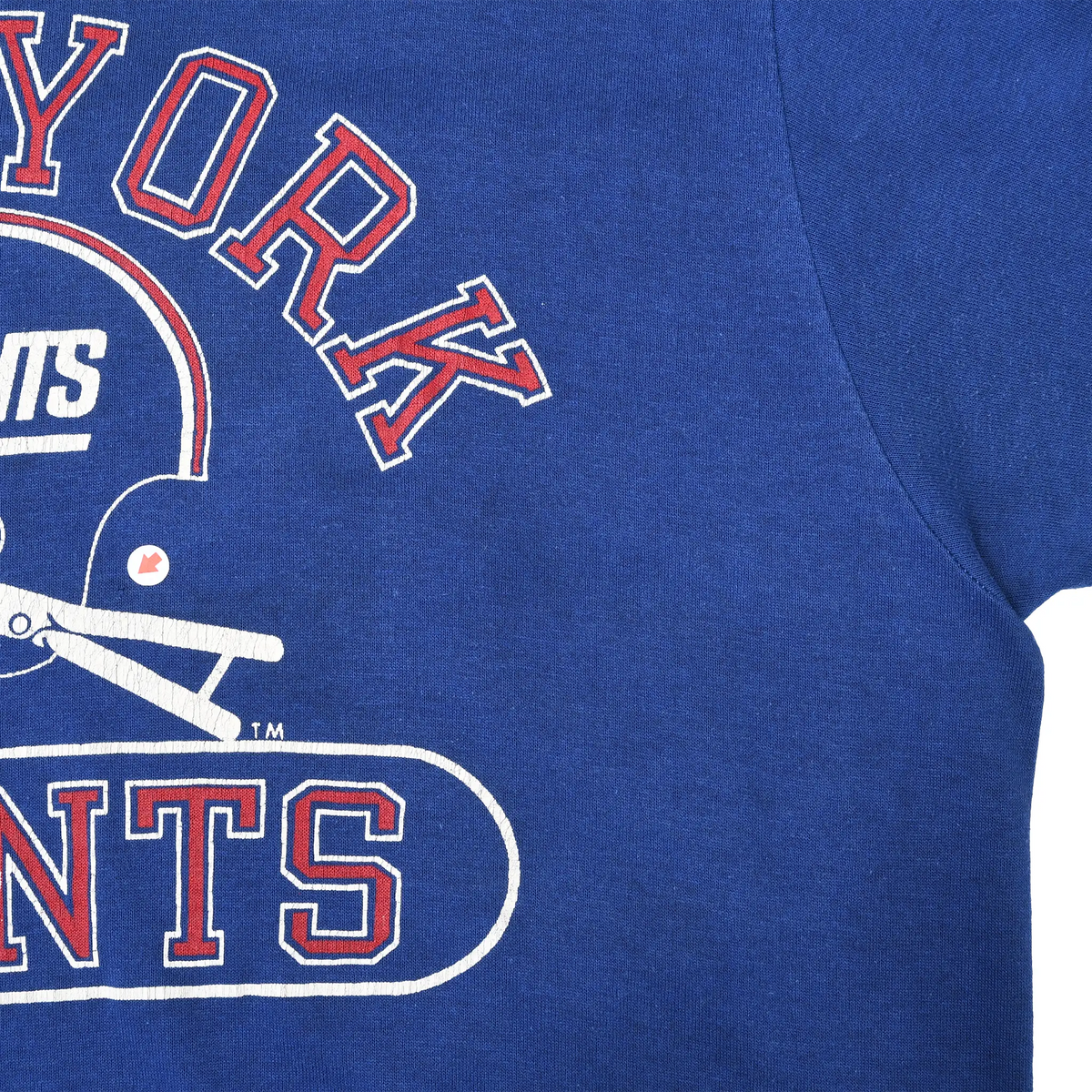 Close-up of New York Giants chest print, blue fabric, and right underarm seam