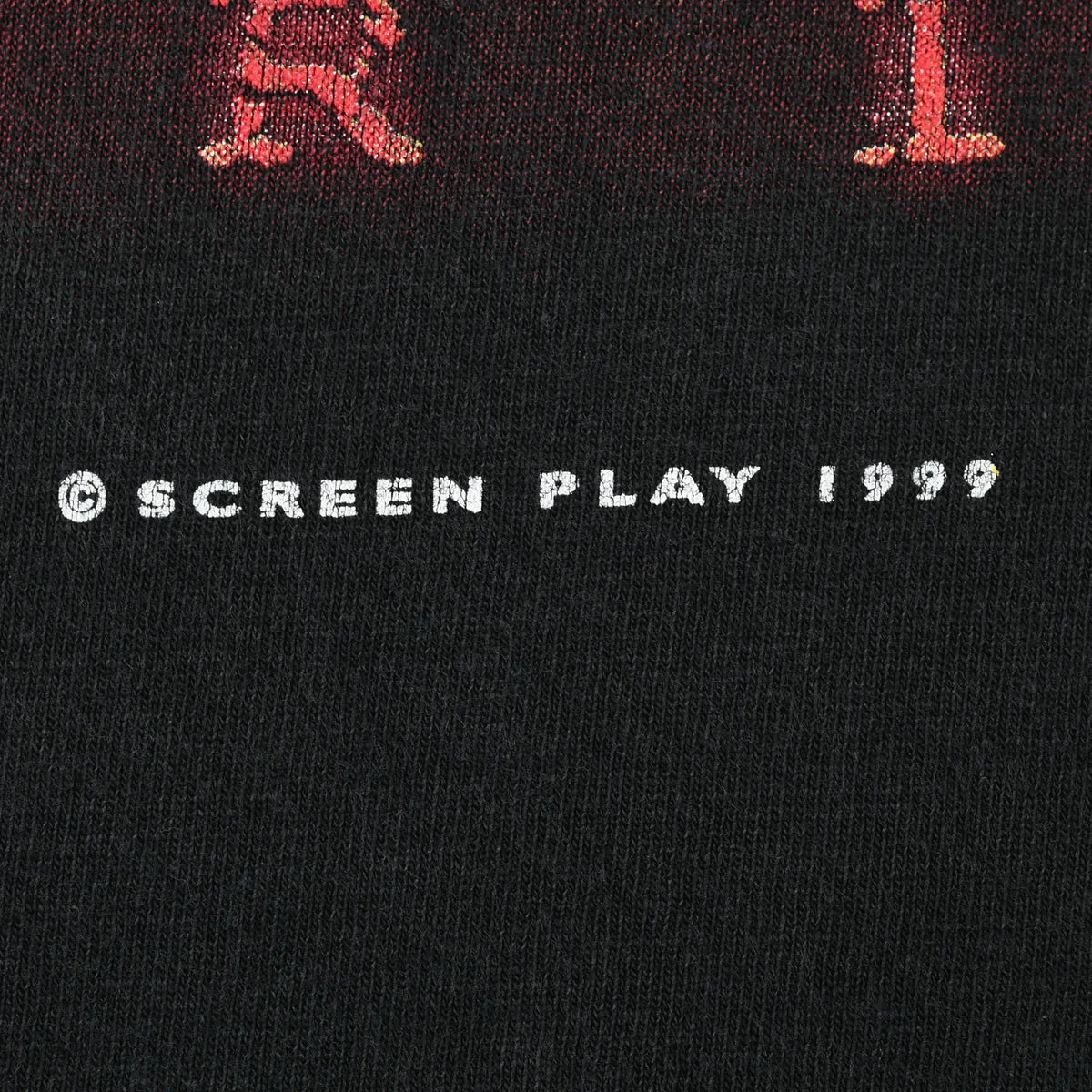 Close-up of Screen Play 1999 copyright text on black fabric