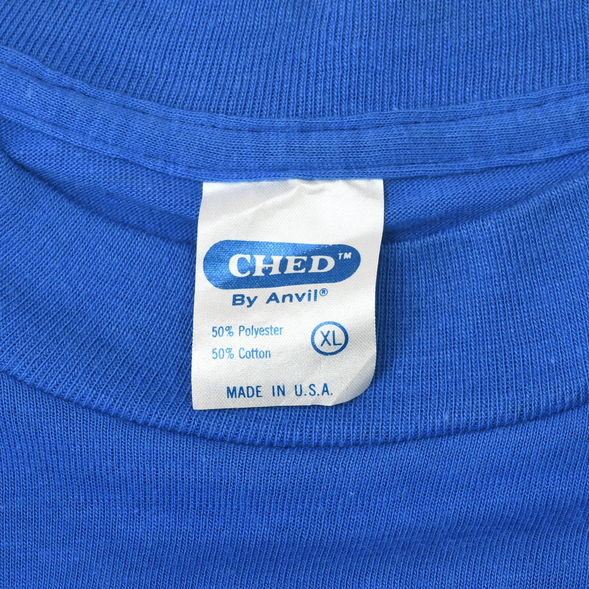 Close-up of CHED by Anvil XL neck tag on blue T-shirt