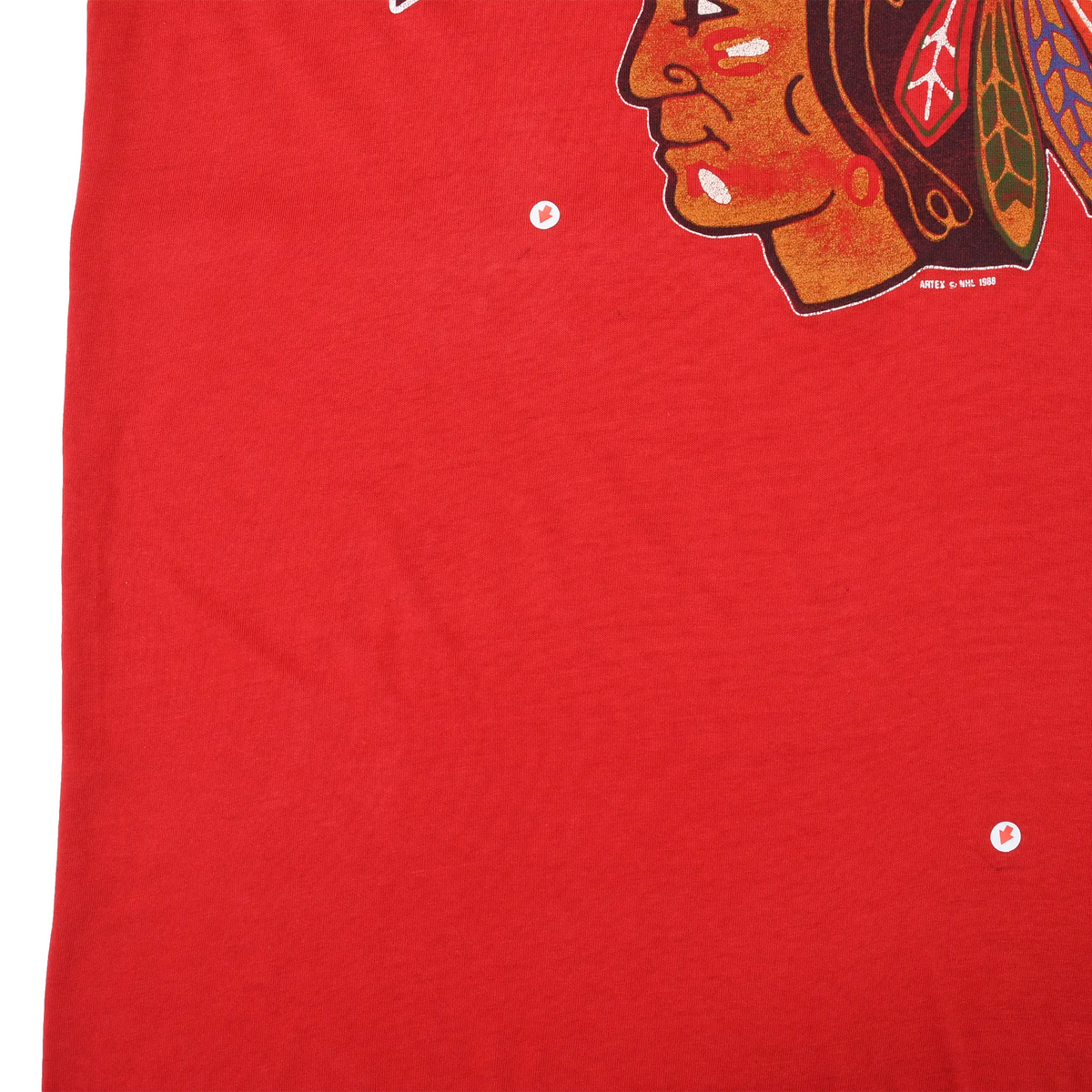 Close-up of red front fabric showing two small holes below the Blackhawks print