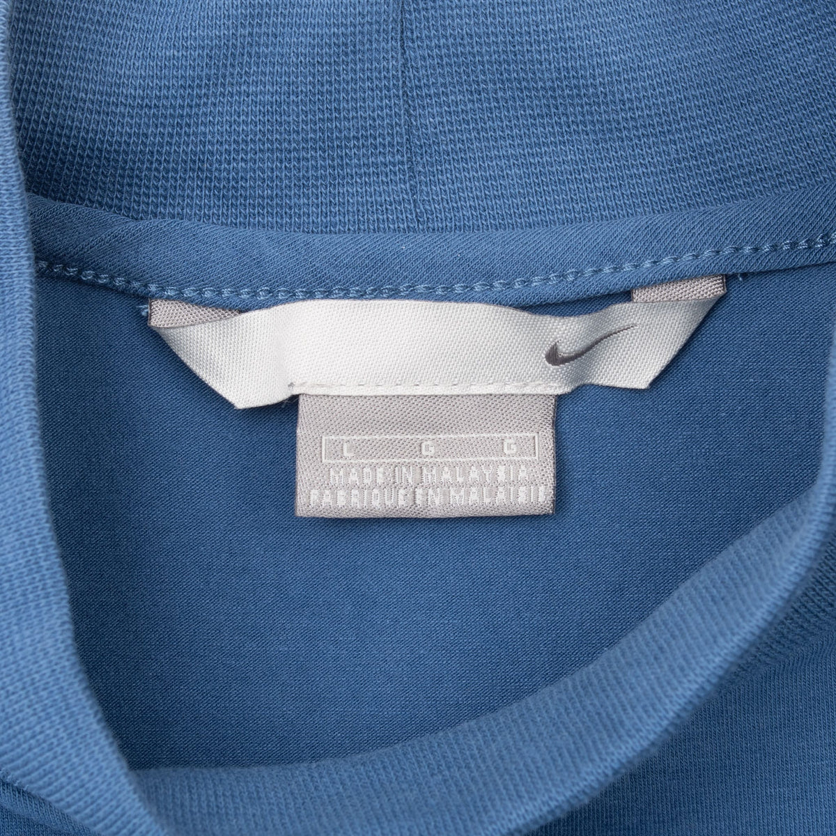 Close-up of Nike neck label inside blue turtleneck shirt