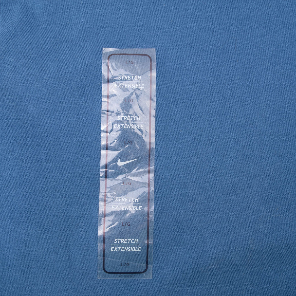 Close-up of original Nike stretch sizing sticker attached to blue shirt front