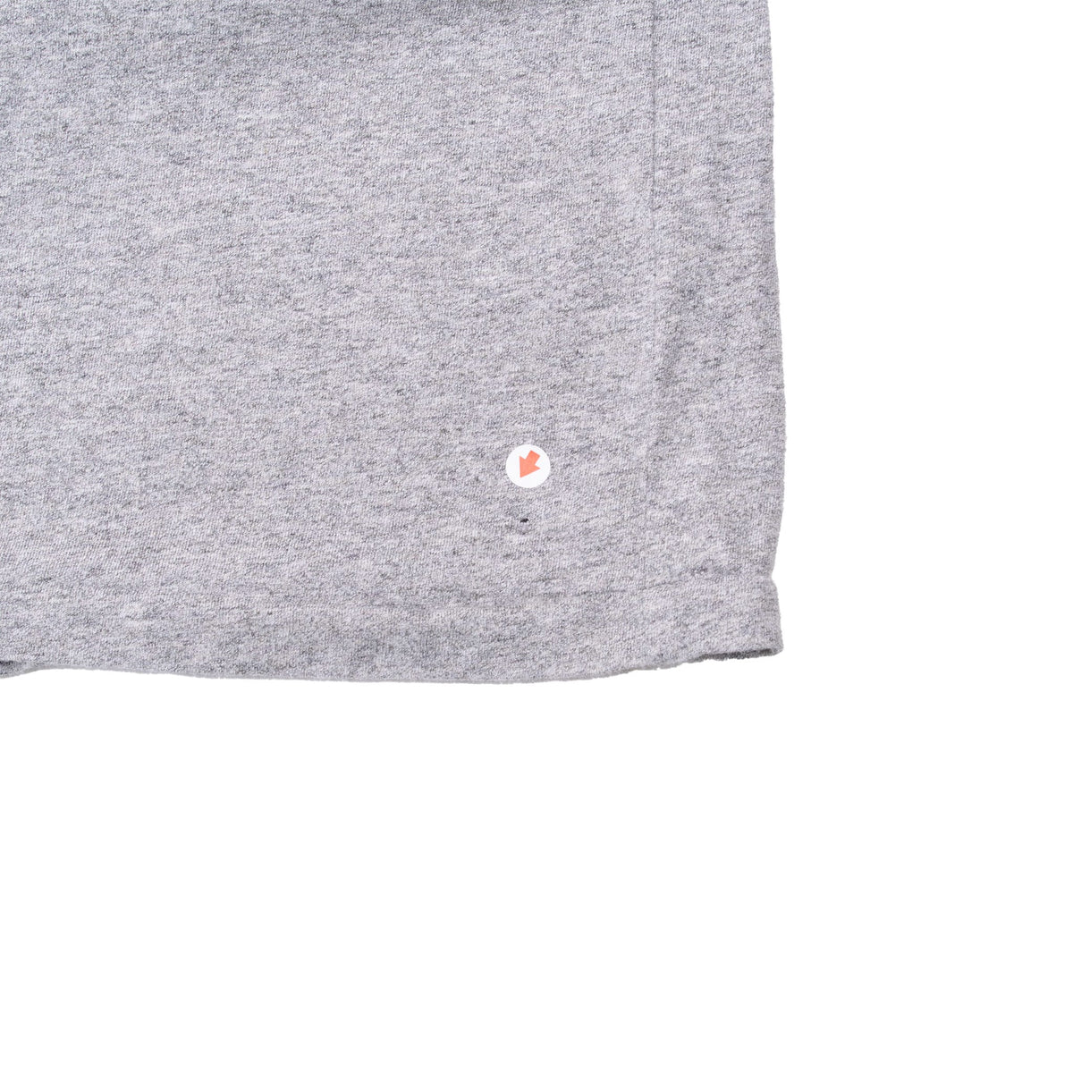 Lower hem detail of grey T-shirt with small red maple leaf emblem