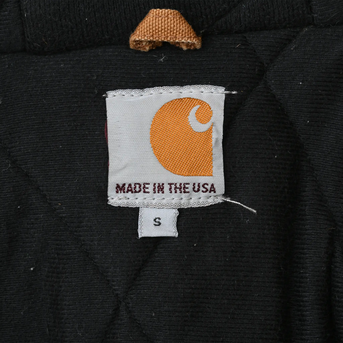Carhartt Made in the USA interior label with small size tag on black lining