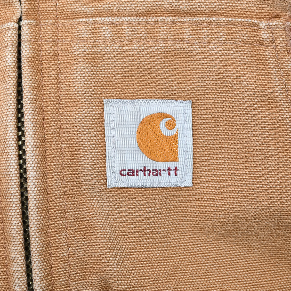 Carhartt logo patch on brown jacket front pocket