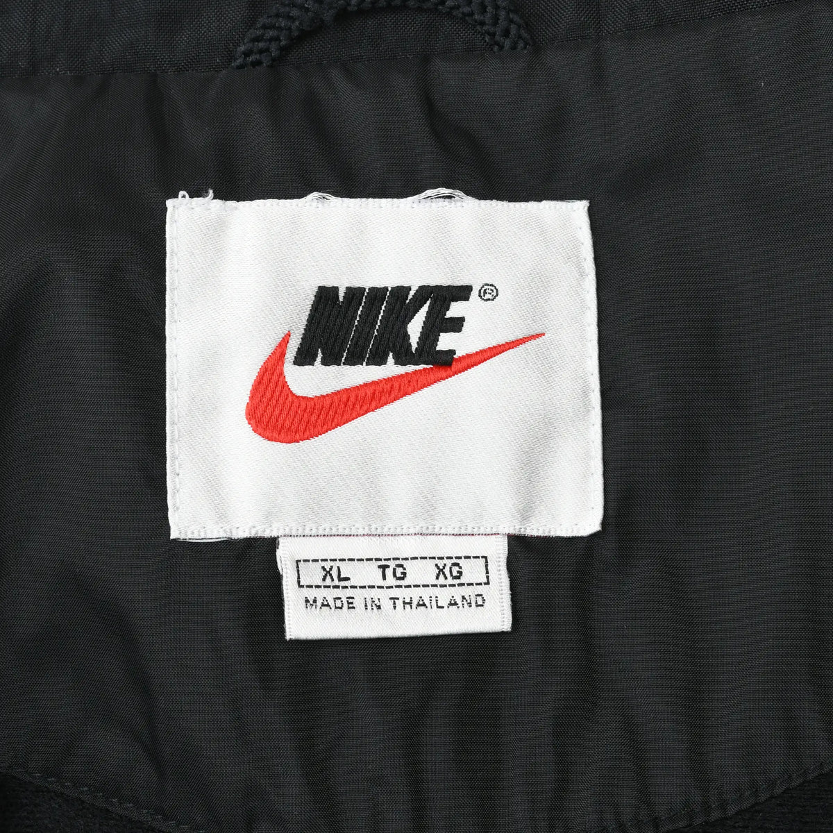 Nike neck label with red Swoosh and XL size tag inside black jacket