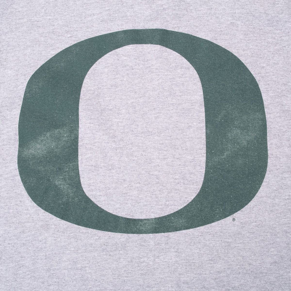 Close-up of large green Oregon O graphic on back of gray T-shirt