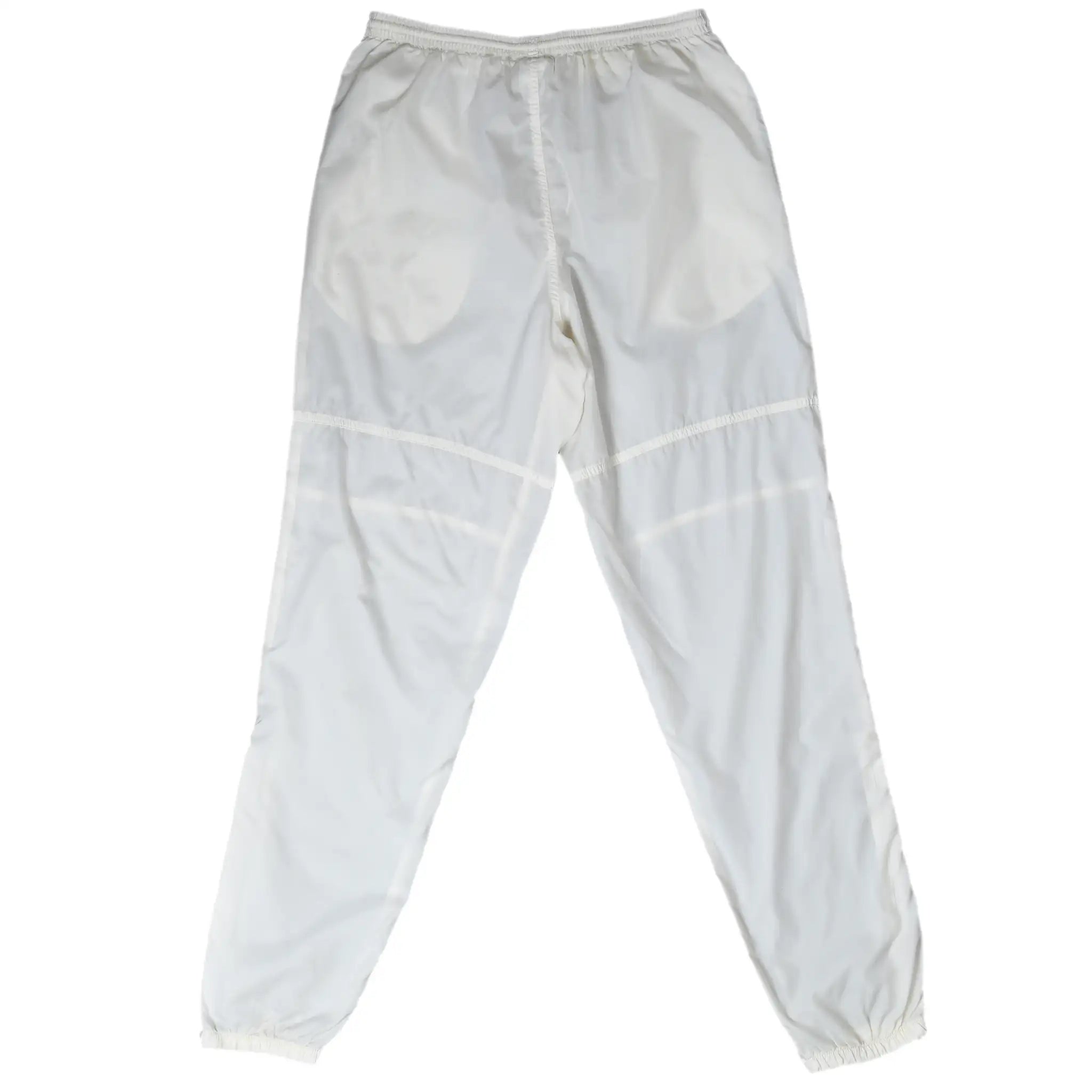 Back of white Nike track pants with elastic waist, curved knee seams, and elastic cuffs