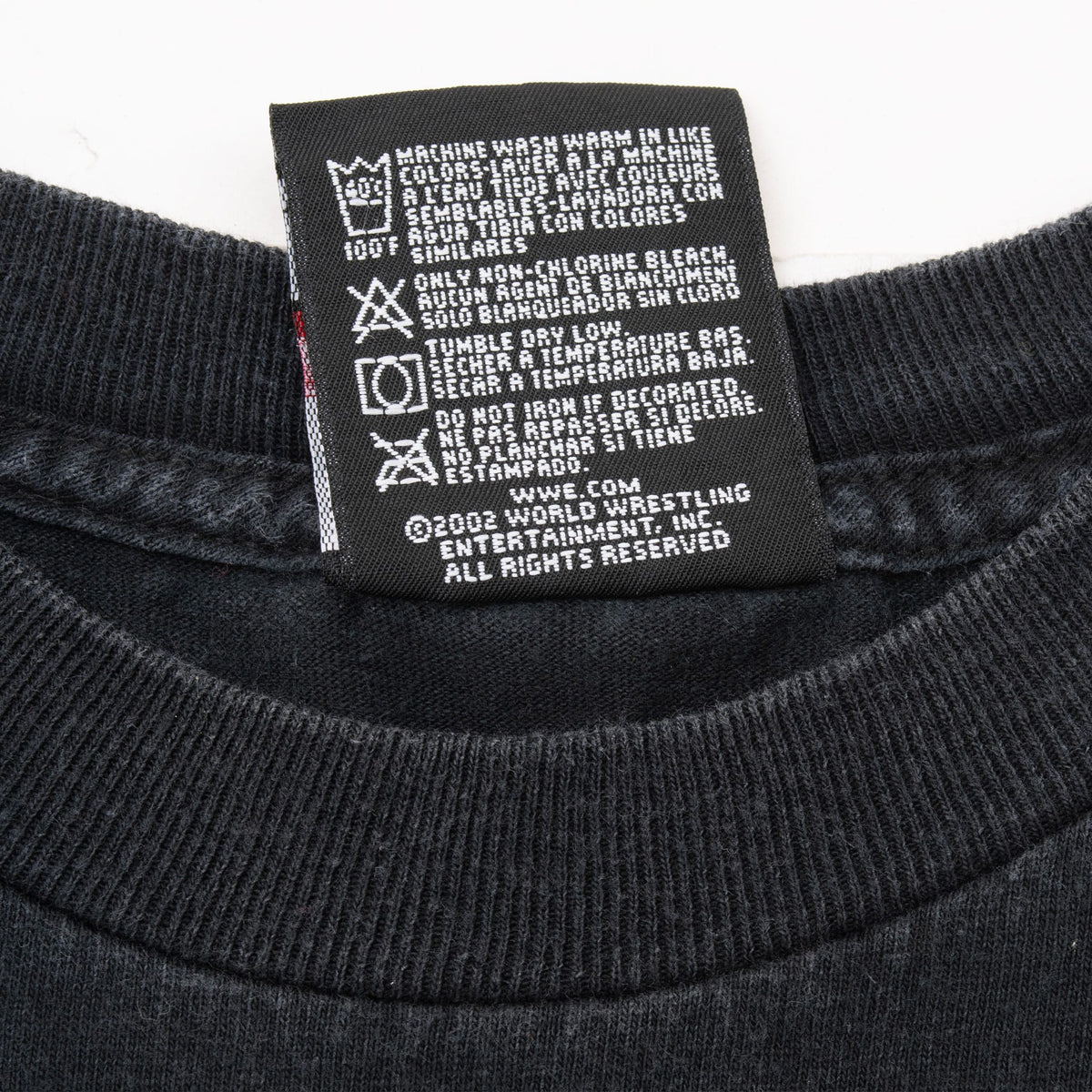 WWE T-shirt care label with washing instructions and 2002 copyright text