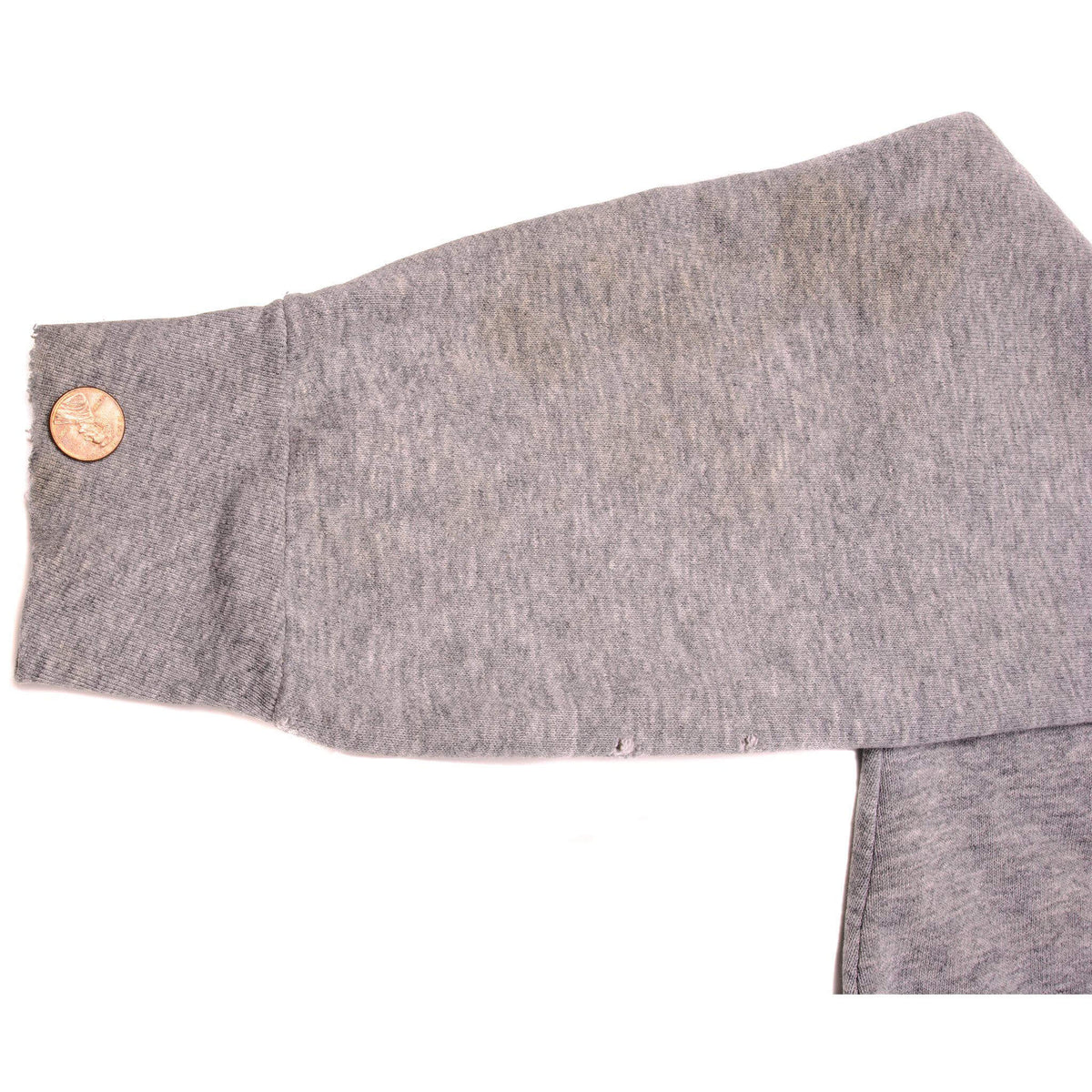 Gray sweatshirt sleeve detail with coin for scale