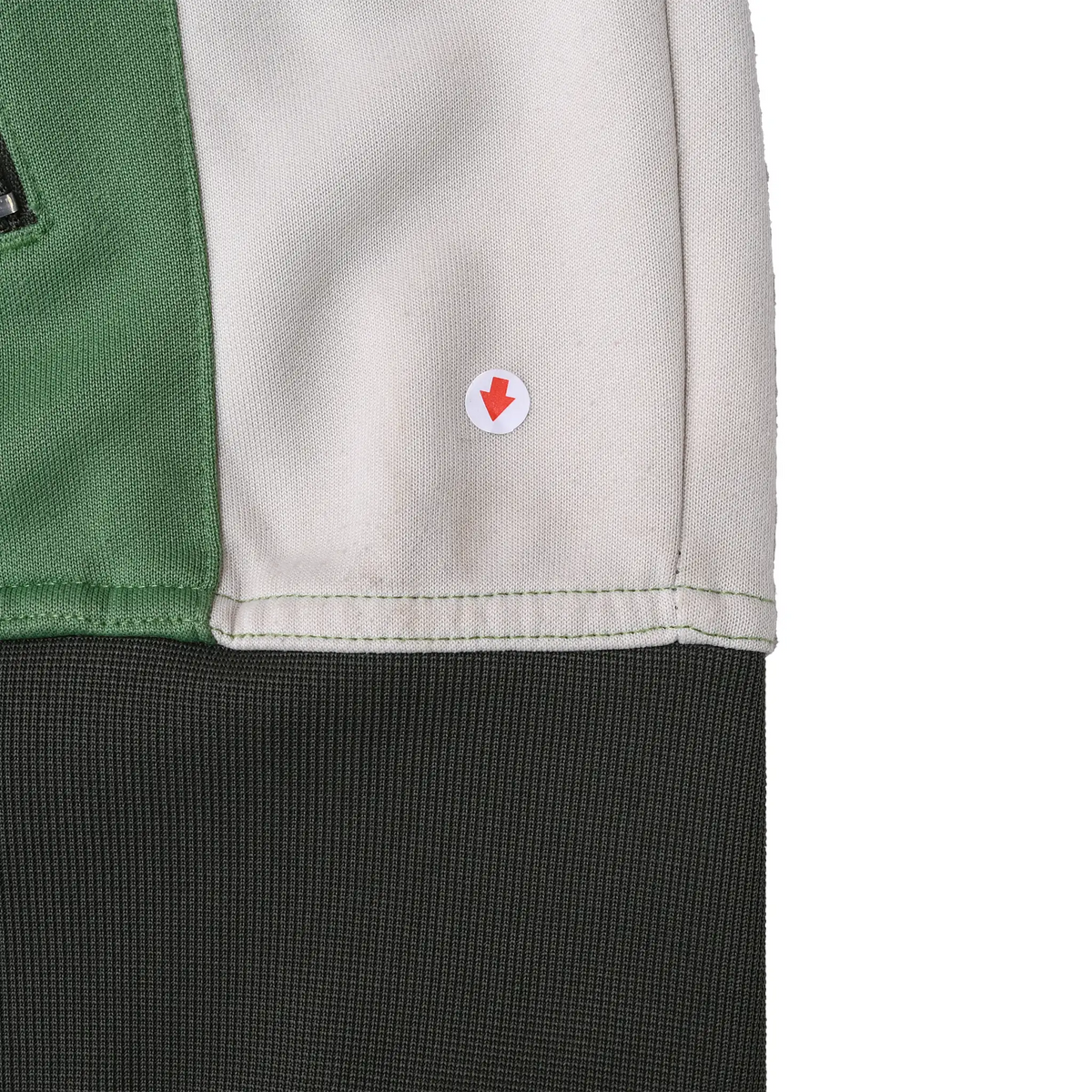 Close-up of interior white panel near dark gray hem with red arrow marking a small spot