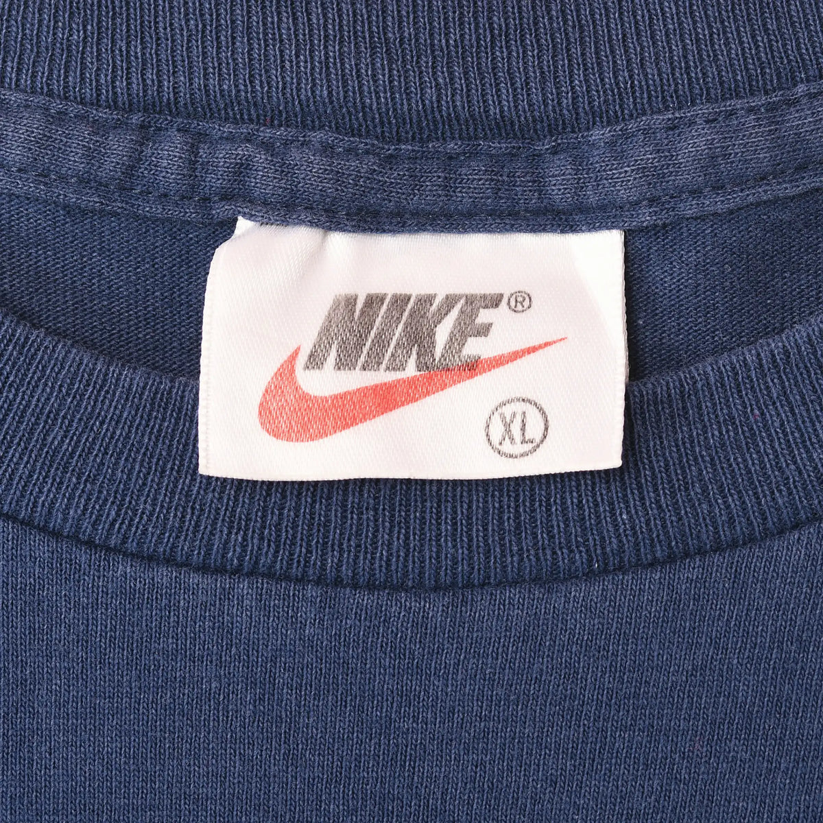 Close-up of Nike neck label marked XL inside blue T-shirt collar