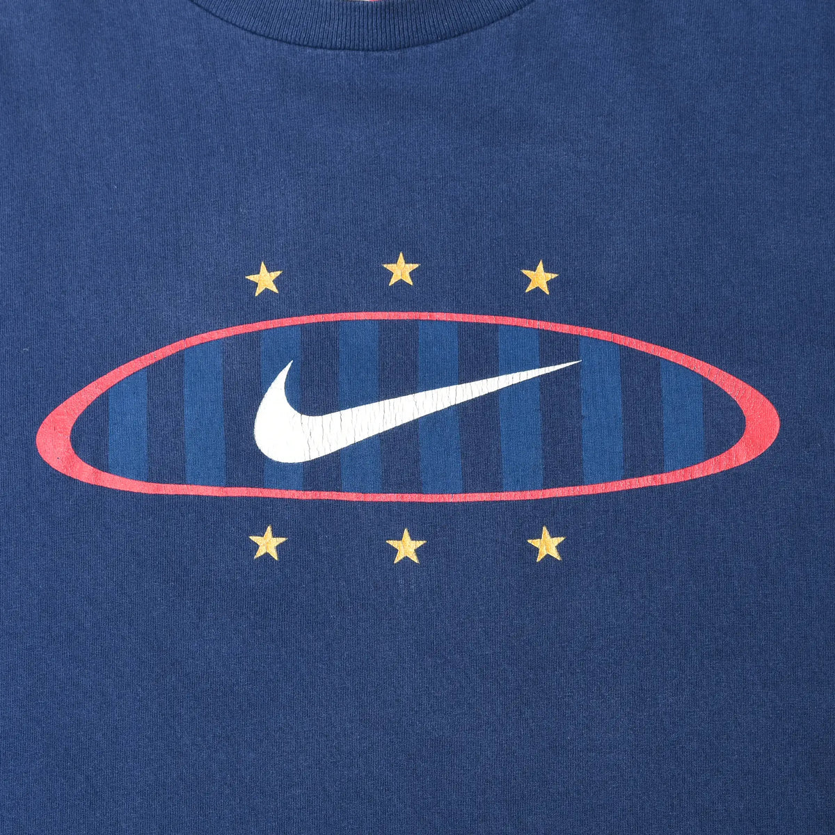 Close-up of front Nike Swoosh graphic with red oval, blue stripes, and six yellow stars