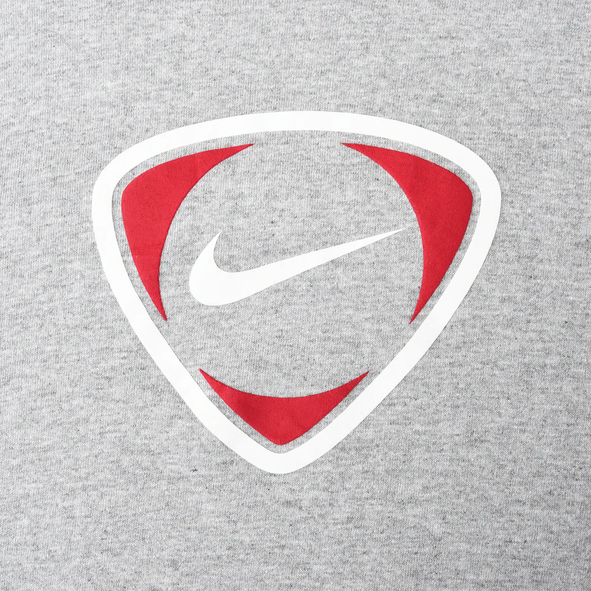 Close-up of red and white Nike Swoosh shield graphic on grey fabric