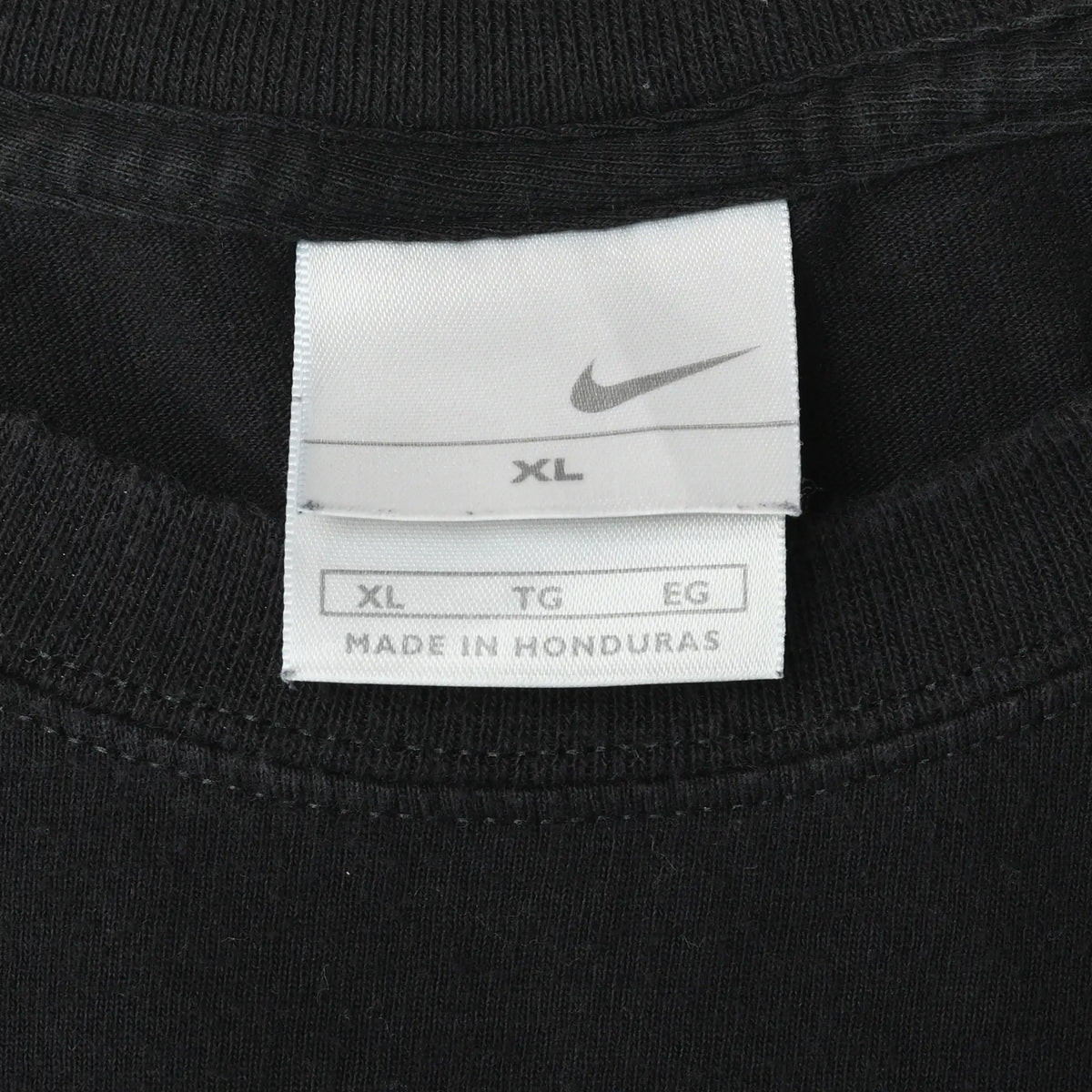 Nike XL neck tag inside black T-shirt, marked Made in Honduras