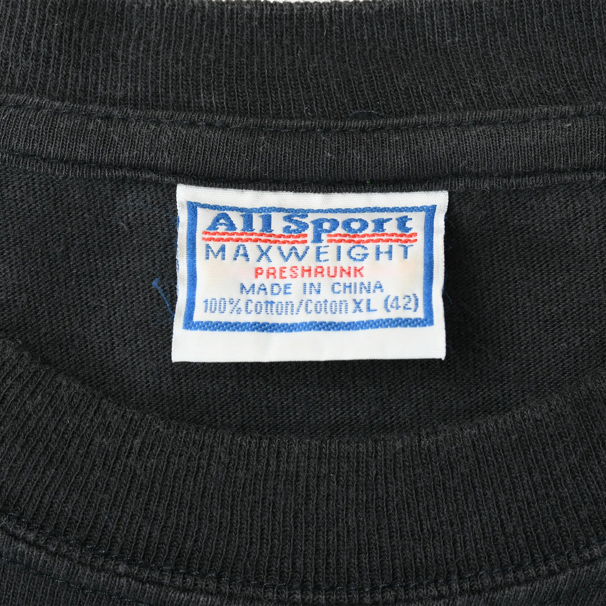 Close-up of Anvil Sport Maxweight neck tag marked preshrunk, 100% cotton, and XL (42)