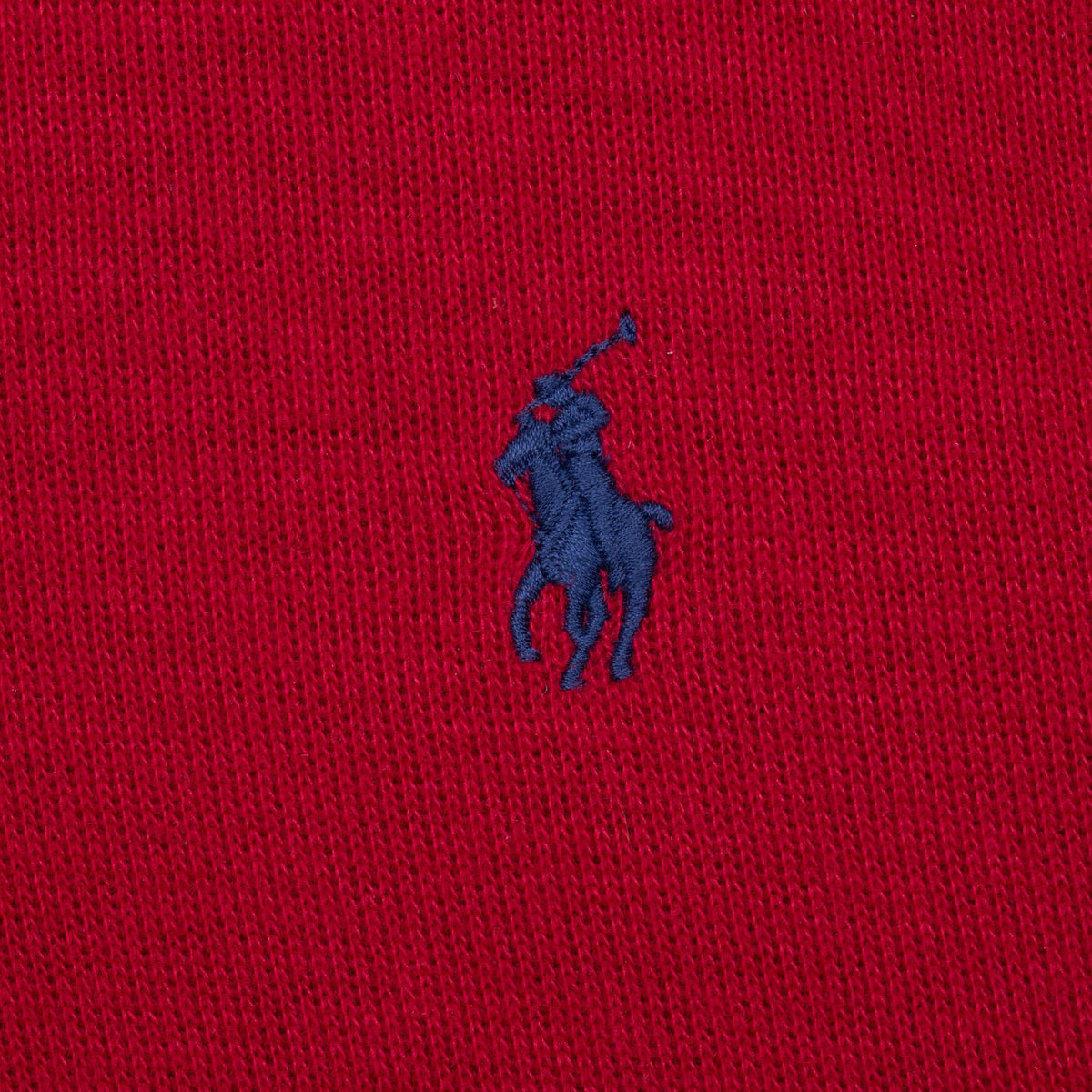 Close-up of navy Polo pony embroidery on red knit fabric