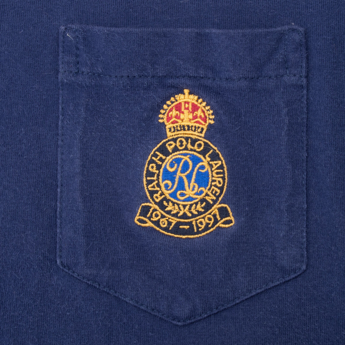 Close-up of gold, red, and blue Polo Ralph Lauren crest embroidered on chest pocket
