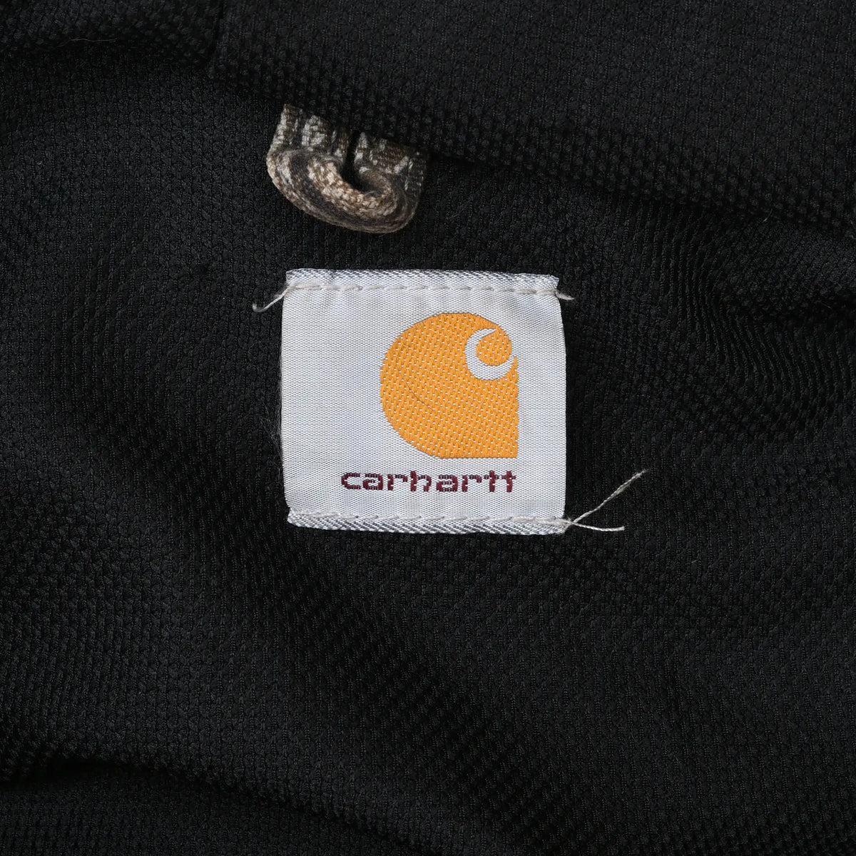 Close-up of Carhartt logo tag on the jacket's black lining