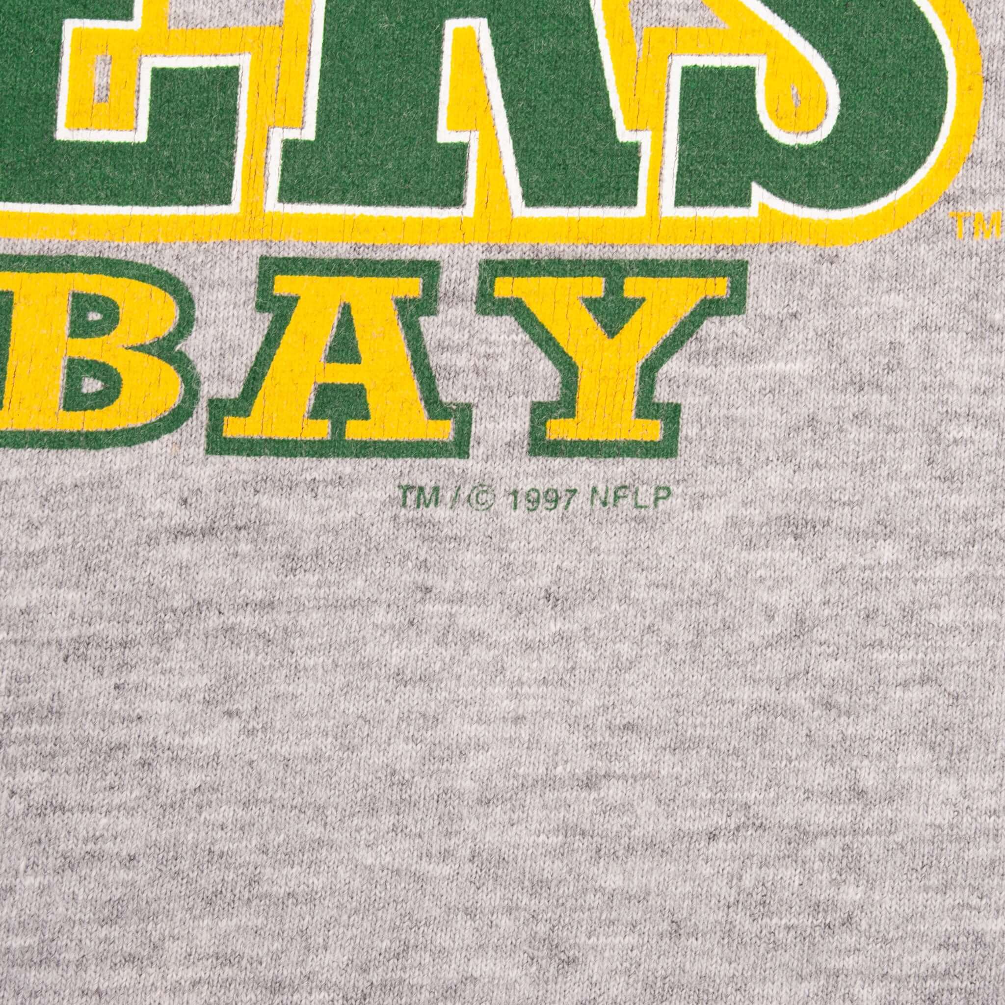 Close-up of green and yellow Packers print with 1997 NFL copyright mark