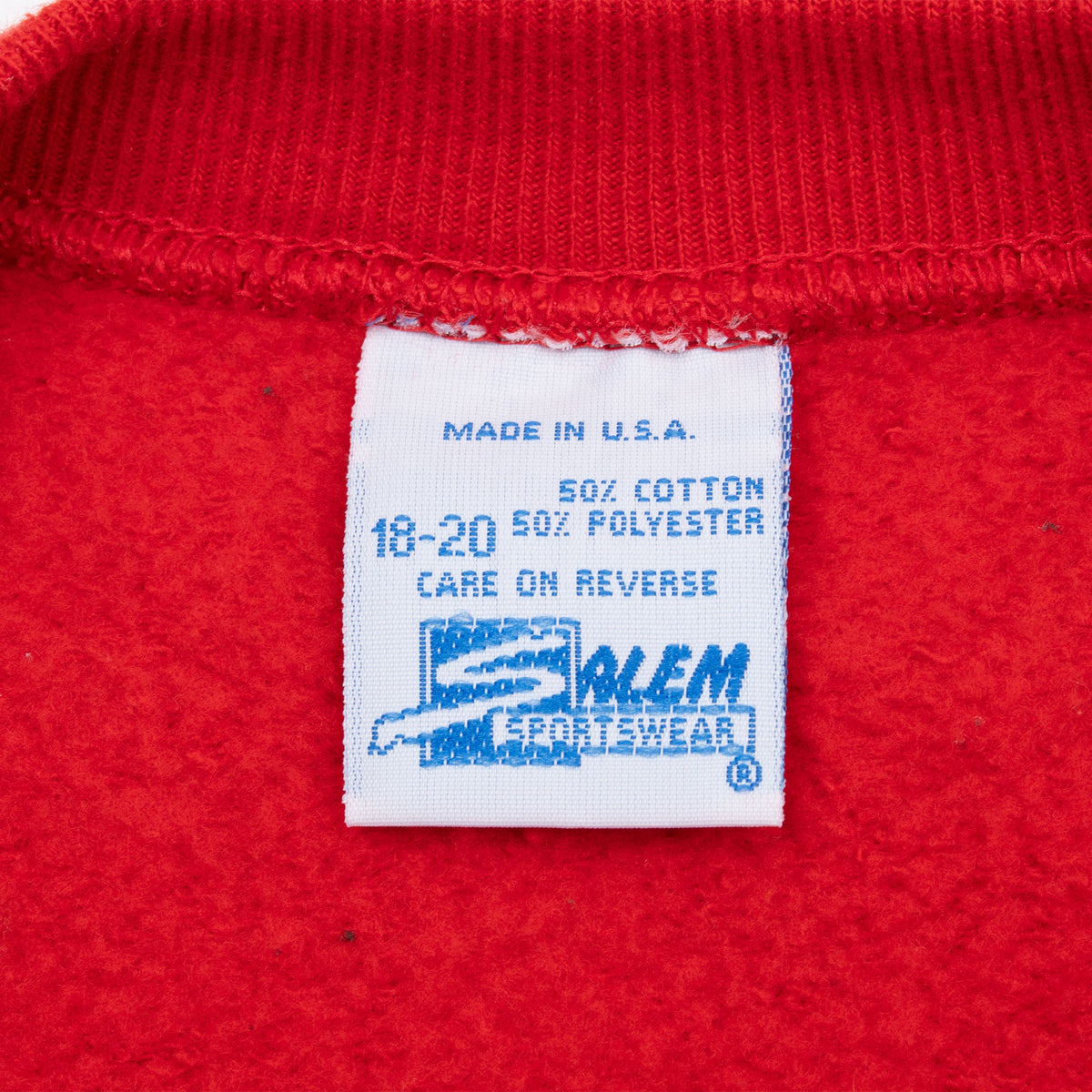Sportswear garment label inside red sweatshirt marked youth 18-20