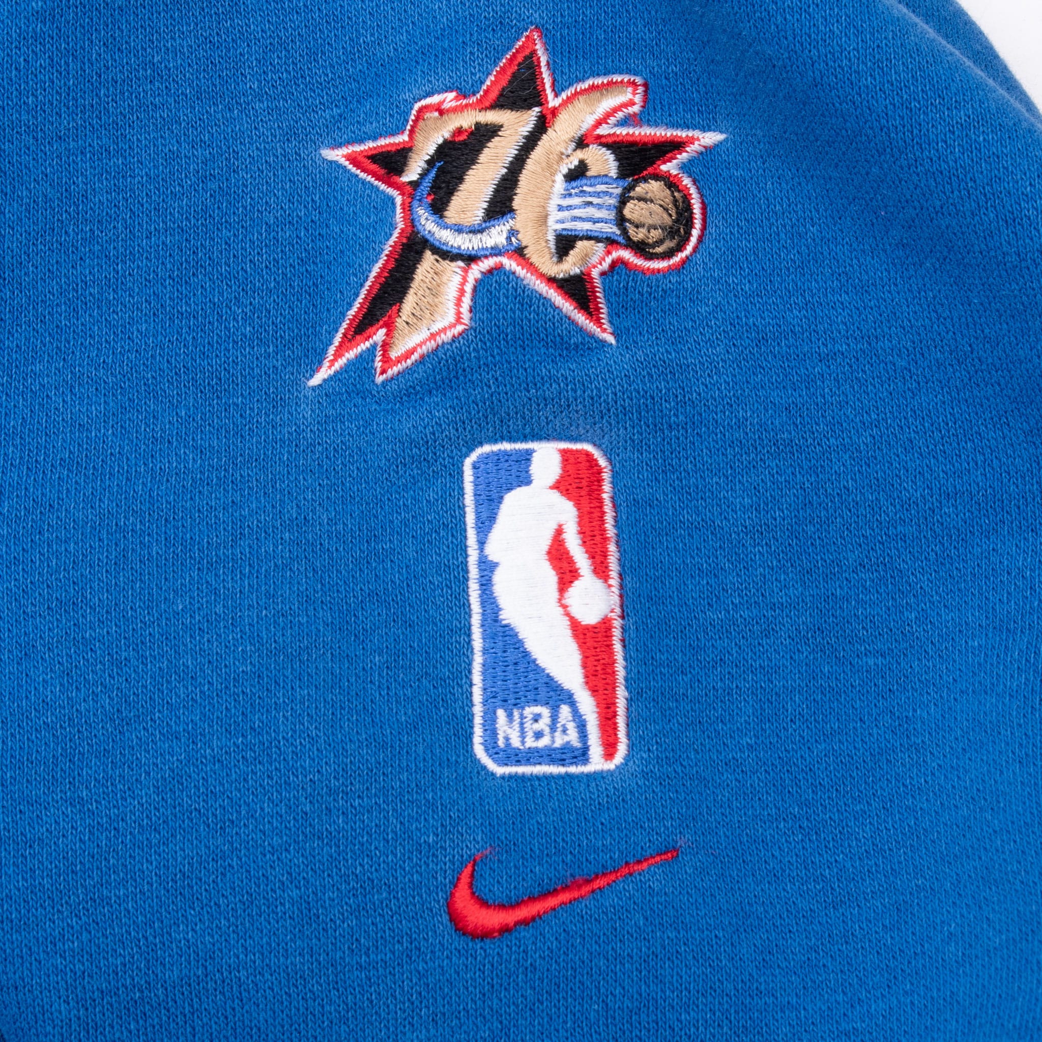 Philadelphia Sixers, NBA, and Nike Swoosh embroidery on blue hoodie sleeve