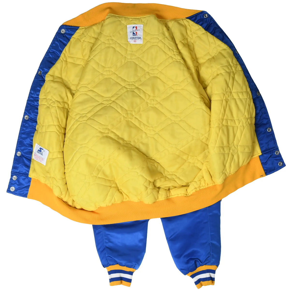 Open Warriors jacket showing yellow quilted lining, interior labels and blue snap placket