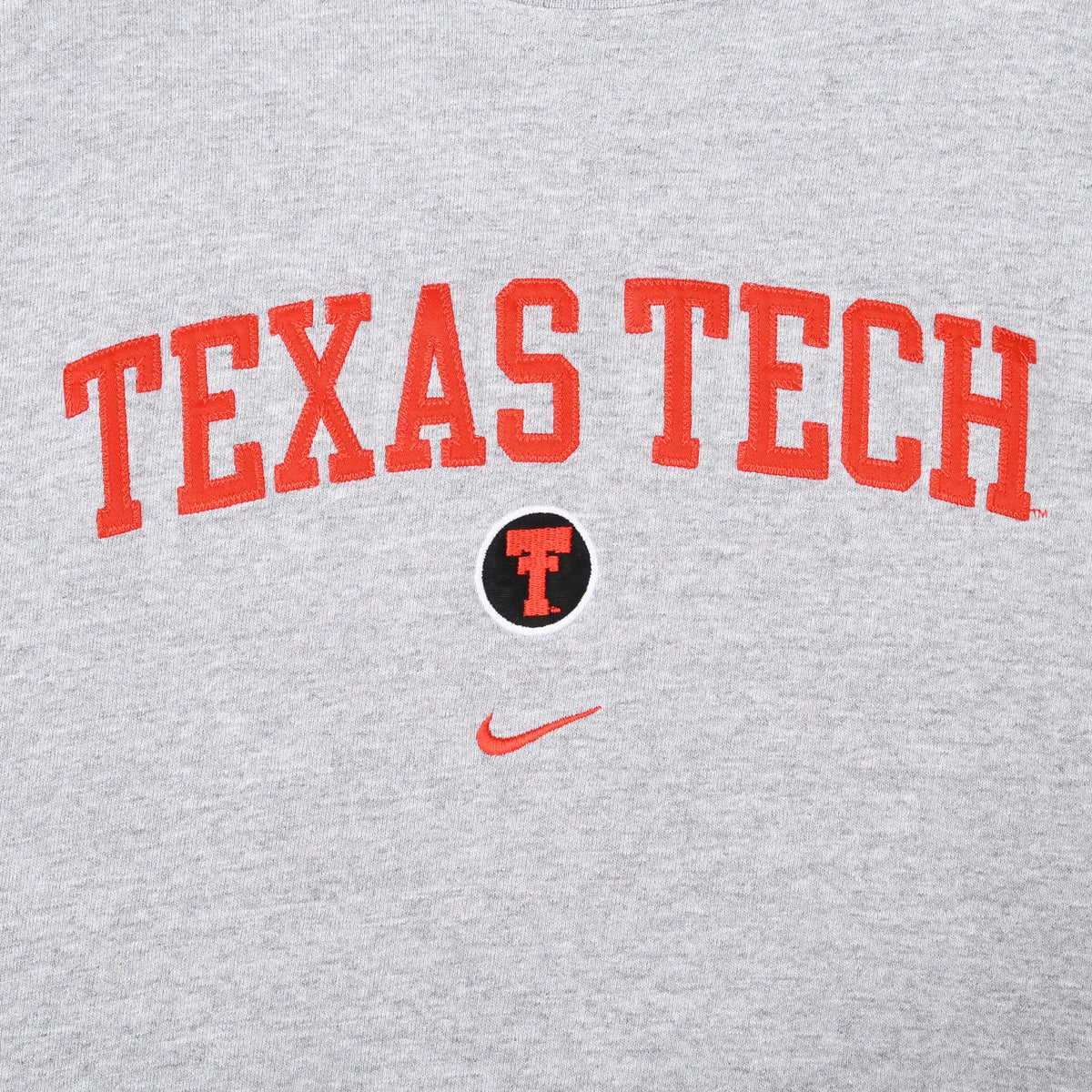 Close-up of red Texas Tech lettering, Double T emblem, and Nike Swoosh