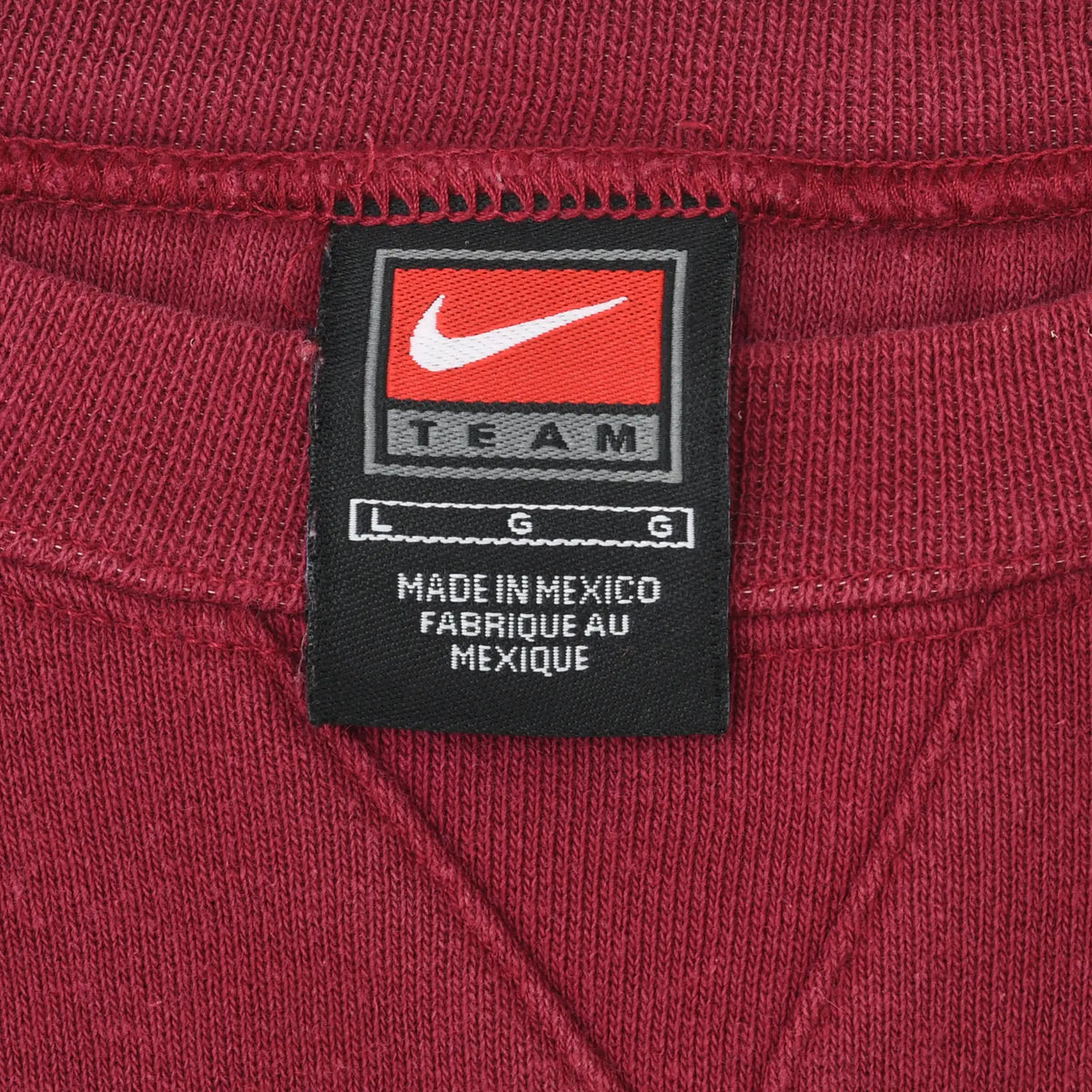 Close-up of Nike Team L/G neck tag inside burgundy crewneck sweatshirt