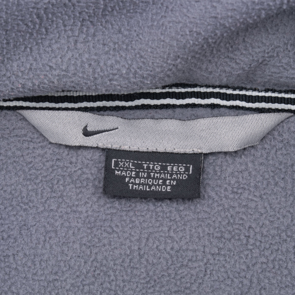 Nike neck and size label marked XXL inside gray fleece-lined jacket