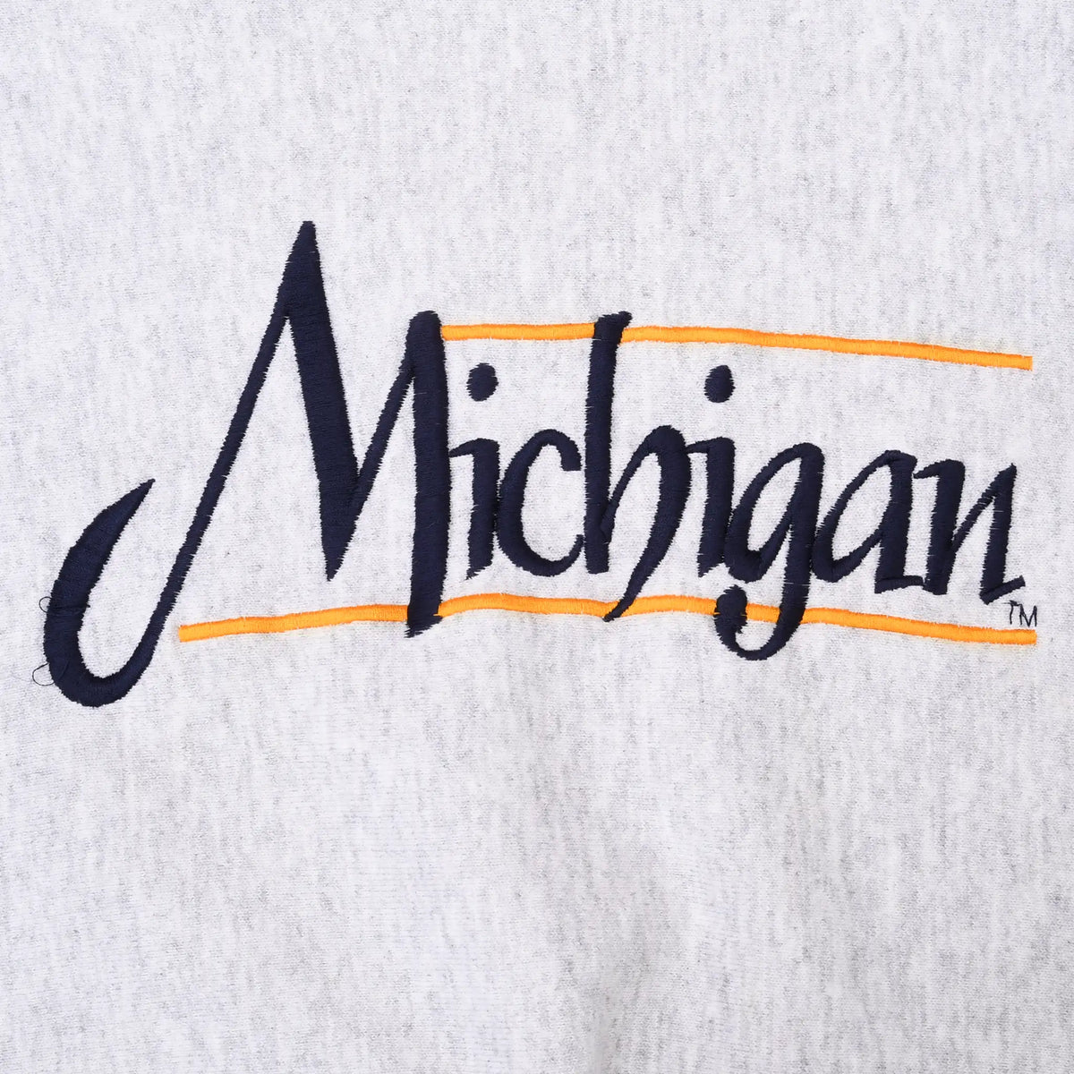 Close-up of navy Michigan script chest embroidery with maize accent lines