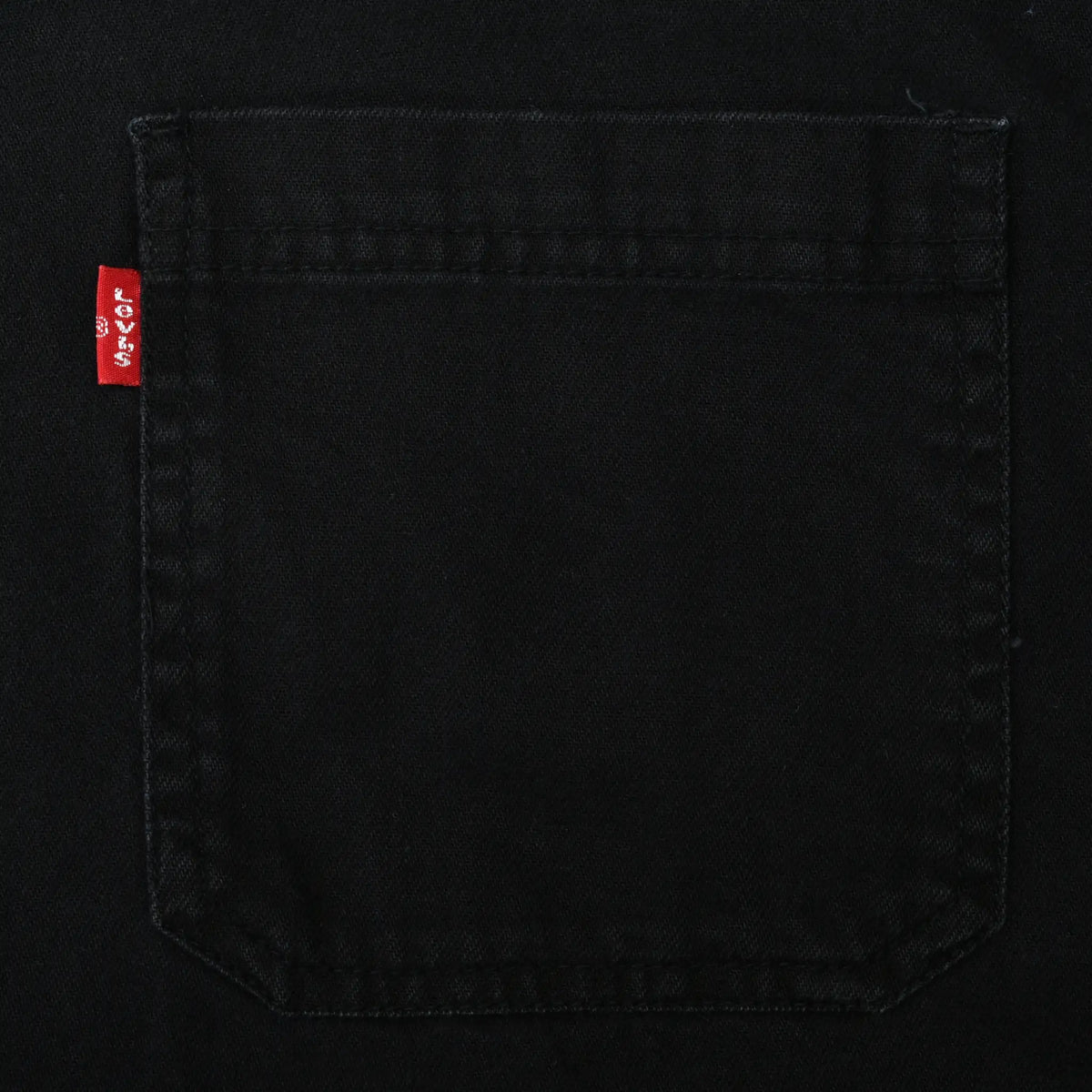 Close-up of black denim chest pocket with red Levi's tab