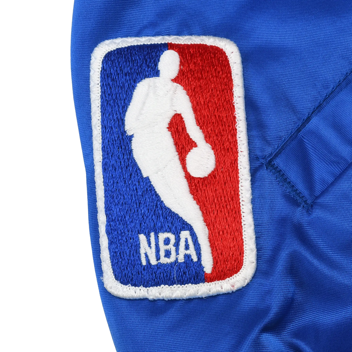 Close-up of embroidered NBA logo patch on blue jacket sleeve