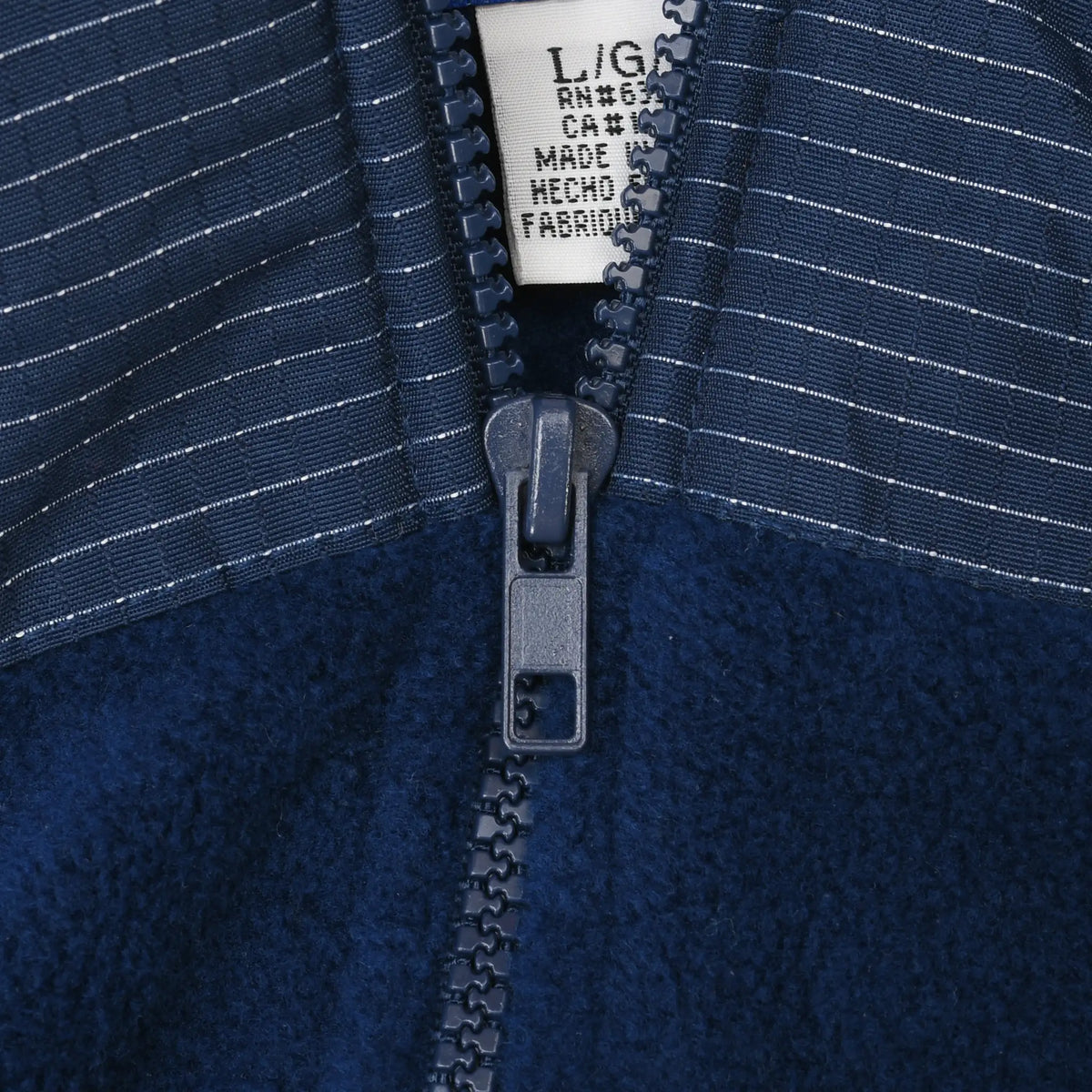 Close-up of quarter zipper and striped fabric on navy St. Louis Blues fleece jacket