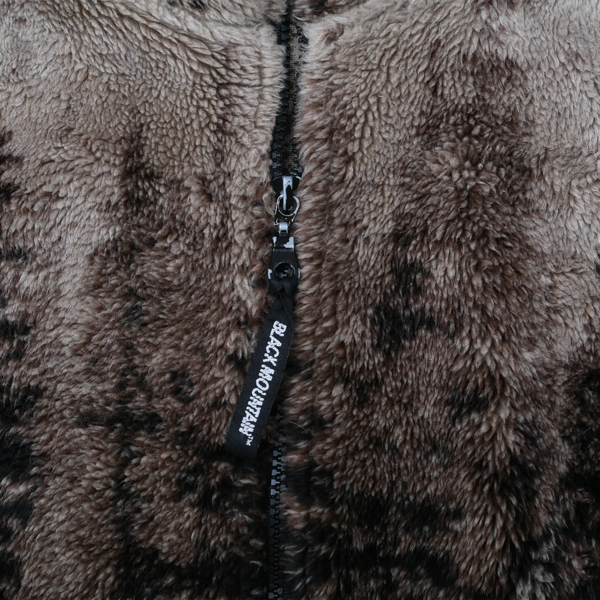 Close-up of black front zipper and Black Mountain pull on brown fleece jacket