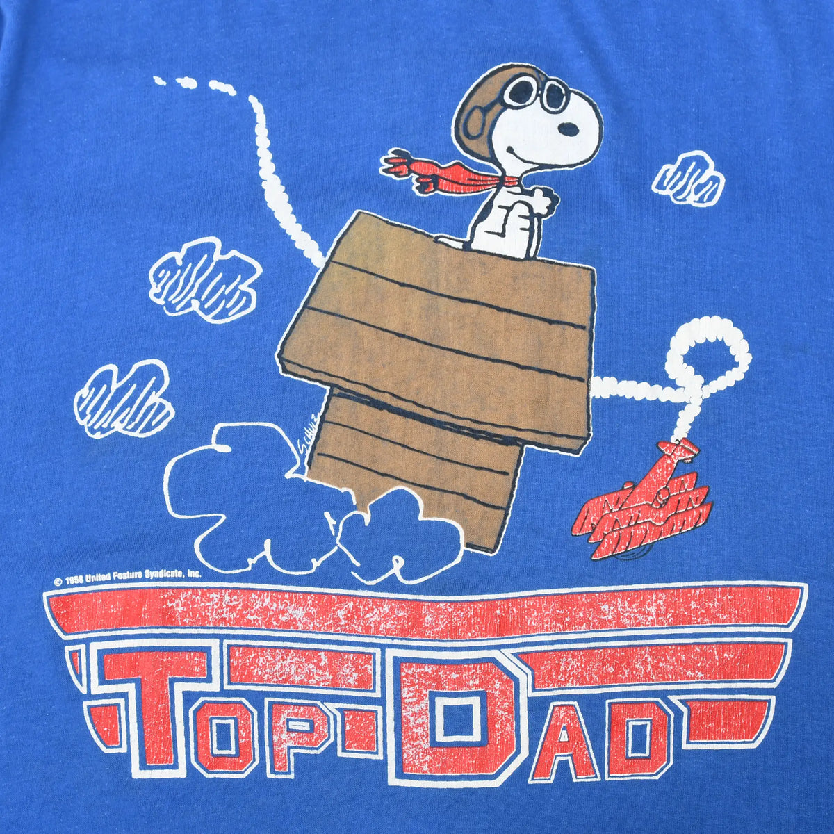 Close-up of Snoopy flying ace atop his doghouse with distressed Top Dad lettering