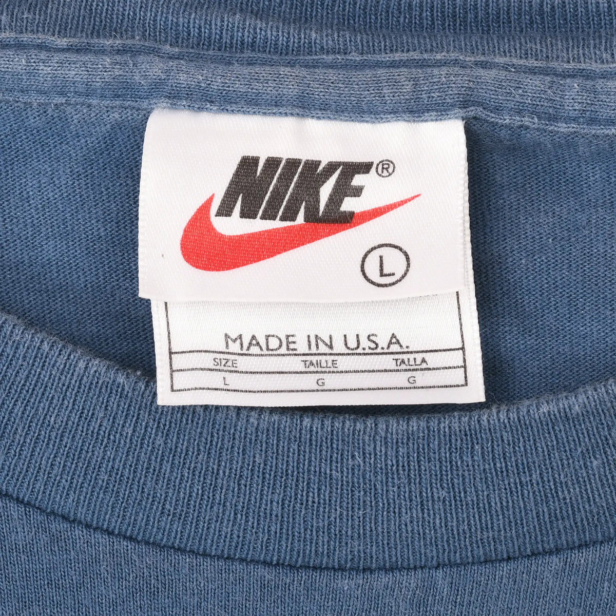 Nike neck tag marked size large and Made in U.S.A. inside blue-grey T-shirt