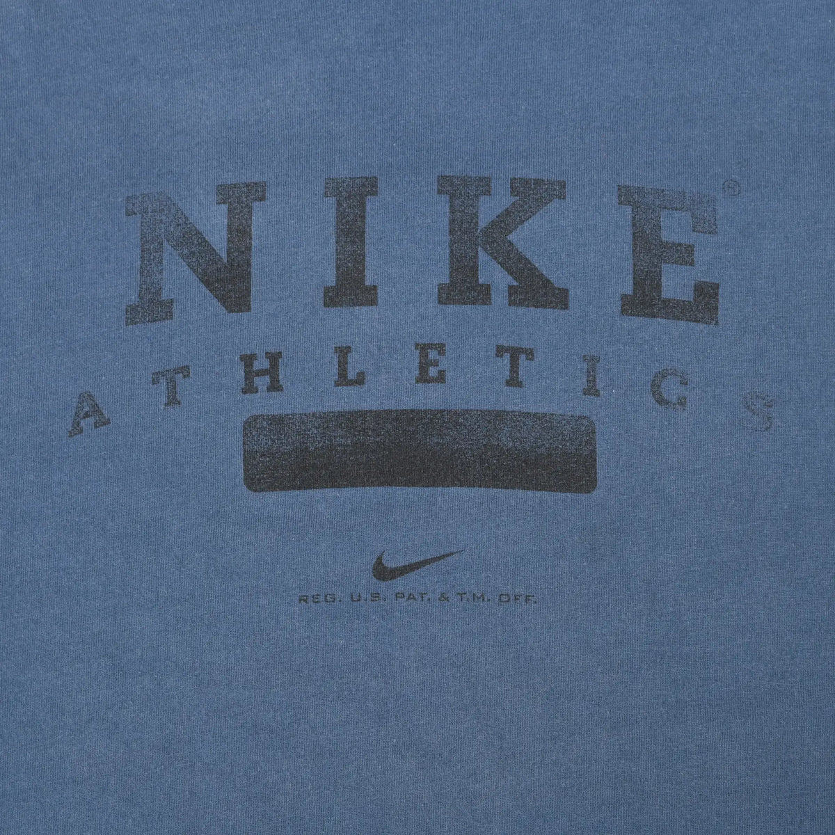 Close-up of black Nike Athletics and swoosh chest print on blue-grey fabric